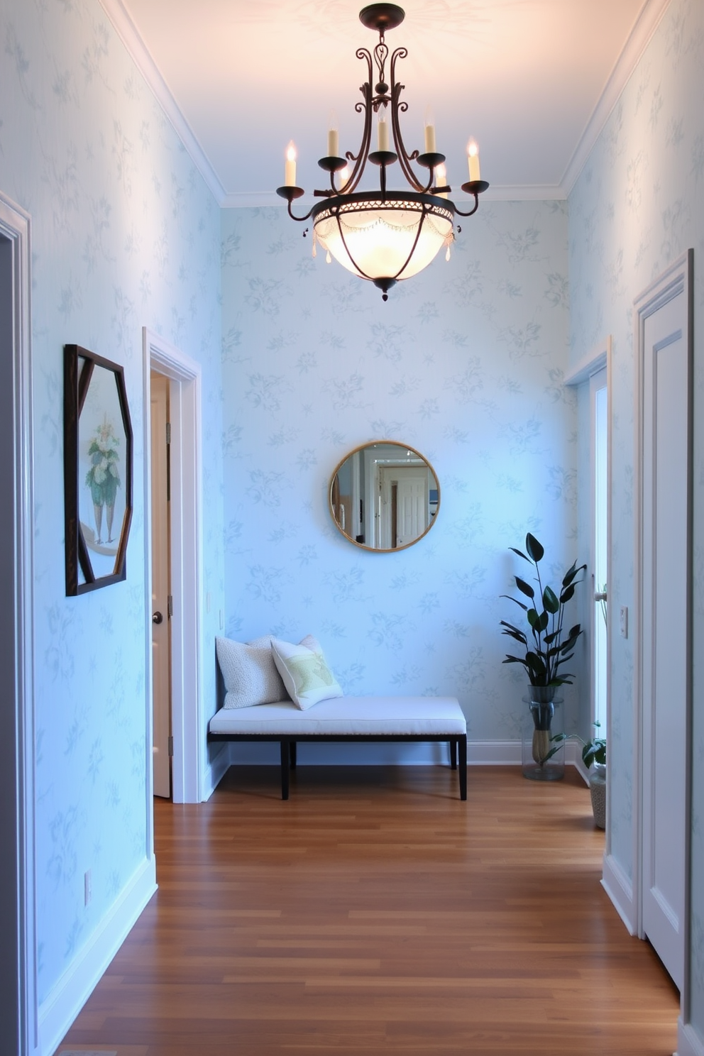 A serene foyer featuring light blue wallpaper adorned with delicate floral patterns. The space is illuminated by a stylish chandelier that casts a warm glow over the polished hardwood floor. A cozy bench with soft cushions is positioned against one wall, providing a welcoming touch. Decorative elements such as a round mirror and potted plants enhance the inviting atmosphere.