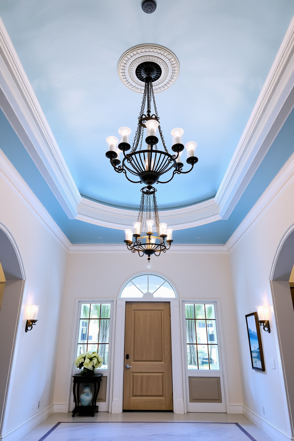 A stunning foyer featuring a sky blue ceiling adorned with elegant chandelier lighting that casts a warm glow throughout the space. The walls are painted in a soft white, complementing the light blue tones and creating a serene atmosphere.