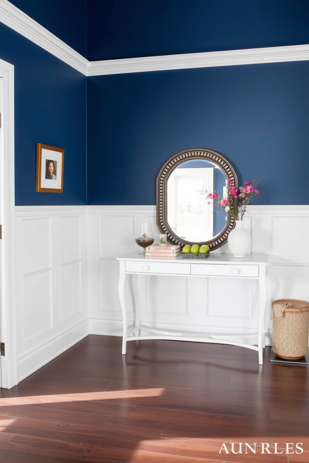 Crisp white wainscoting lines the lower half of the foyer, providing a clean and elegant contrast to the rich blue paint that adorns the upper walls. A stylish console table sits against the wall, topped with a decorative mirror and a few carefully curated accessories to enhance the welcoming atmosphere.