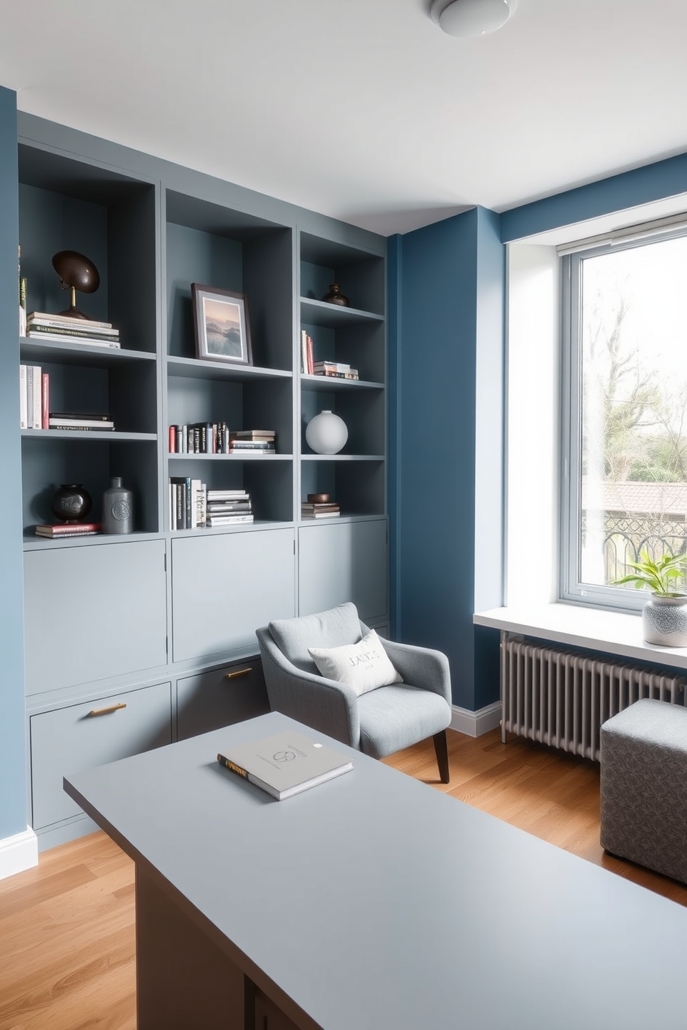 A modern blue and gray minimalist home library features sleek built-in shelves that showcase a curated collection of books and decorative objects. A comfortable reading nook with a plush gray armchair sits beside a large window, allowing natural light to flood the space. The walls are painted in a soft blue hue, creating a serene atmosphere. A simple, low-profile desk in a matching gray tone provides a functional workspace without overwhelming the room's minimalist aesthetic.