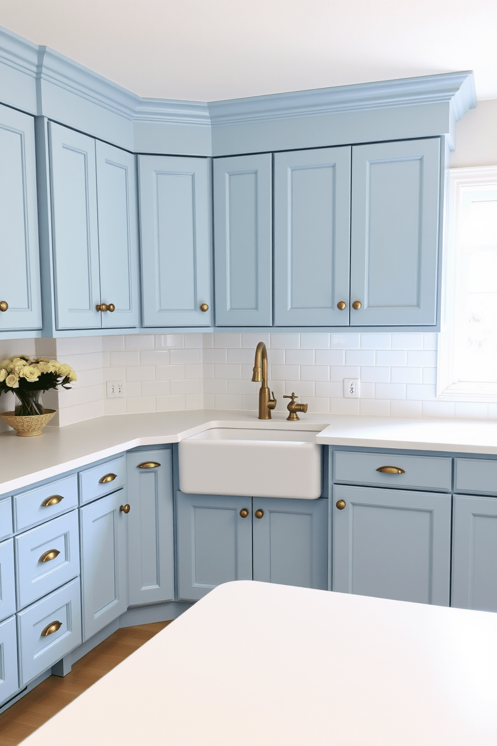 Light blue shaker cabinets with brass hardware create a fresh and inviting atmosphere in the kitchen. The countertops are a crisp white quartz, complementing the cabinetry while adding a touch of elegance. A large farmhouse sink is centered beneath a window, allowing natural light to flood the space. The backsplash features a classic subway tile in a glossy finish, enhancing the overall brightness of the kitchen.