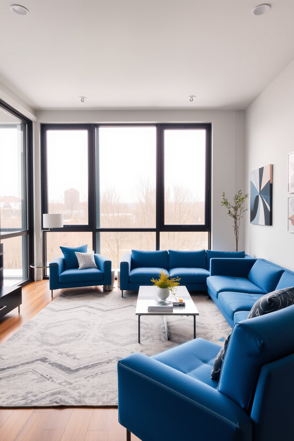 A contemporary living room featuring blue furniture with sleek lines. The space is accented with minimalist decor and large windows allowing natural light to flood in.