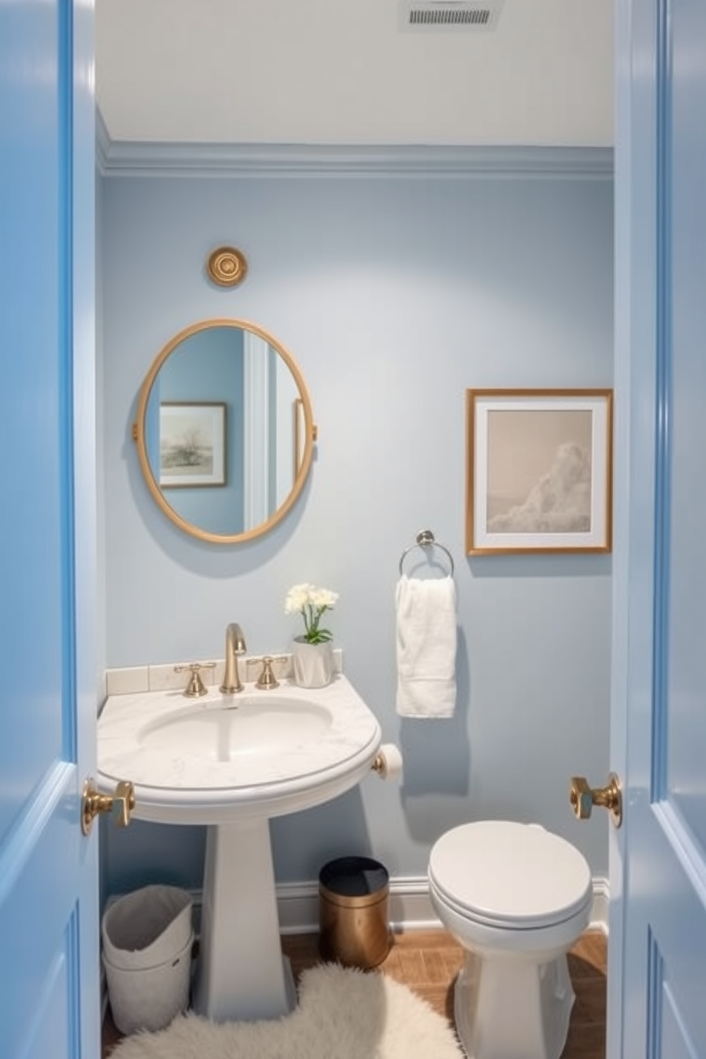 A cozy powder room with soft blue lighting creates a serene atmosphere. The walls are painted in a soft powder blue, complementing elegant white fixtures and a chic marble countertop. A stylish round mirror with a delicate gold frame hangs above the sink. A plush white rug adds warmth underfoot, while tasteful artwork in subtle hues enhances the room's charm.