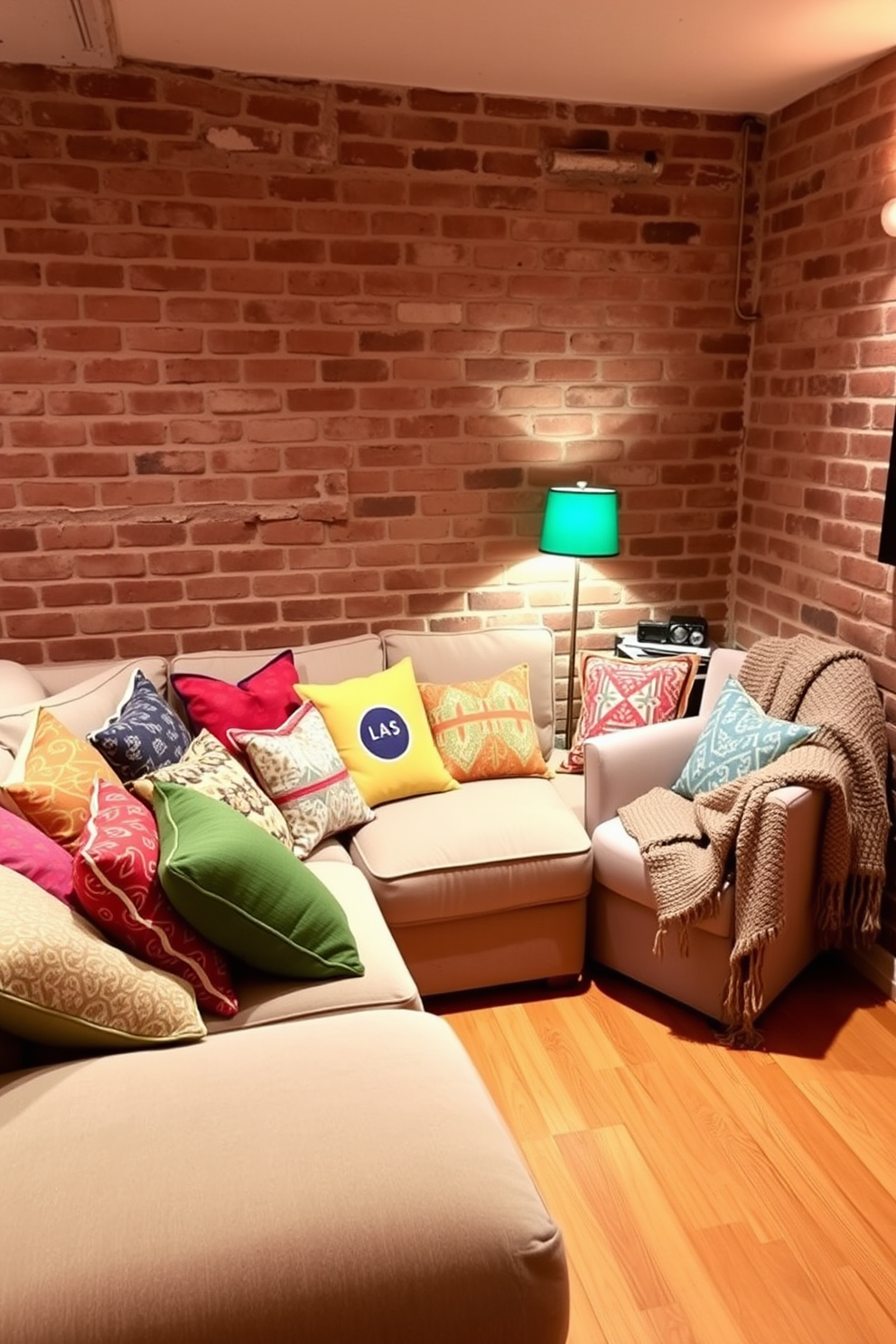 Colorful throw pillows in various patterns and textures are scattered across a plush sectional sofa, adding a vibrant touch to the cozy brick basement. The walls are exposed brick, creating a rustic charm, while soft lighting enhances the inviting atmosphere. In one corner, a small reading nook features a comfortable armchair draped with a knitted blanket, complemented by a vibrant floor lamp. The flooring is a warm wood finish, contrasting beautifully with the brick and creating a welcoming space for relaxation.