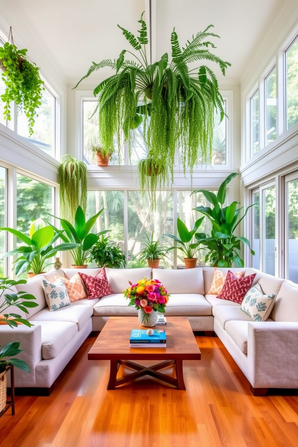 A bright and airy California living room filled with lush greenery. Large windows allow natural light to flood the space, showcasing potted plants and hanging ferns that create a tropical atmosphere. The seating area features a comfortable sectional sofa in a light fabric complemented by colorful throw pillows. A wooden coffee table sits in the center, adorned with a vibrant floral arrangement and a few art books.