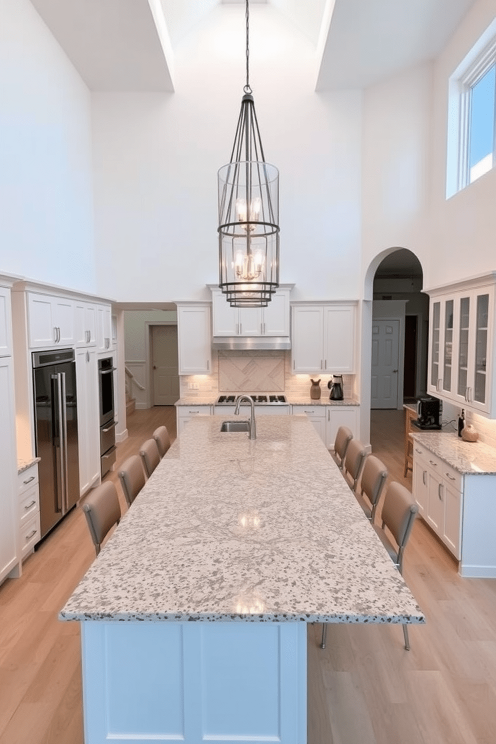 A spacious kitchen with high ceilings that create an open and airy atmosphere. The design features a large island in the center, topped with a polished granite surface, surrounded by high-backed stools. Elegant pendant lights hang from the ceiling, illuminating the space with a warm glow. Sleek cabinetry in a soft white finish complements the stainless steel appliances, while a stylish backsplash adds a touch of color and texture.