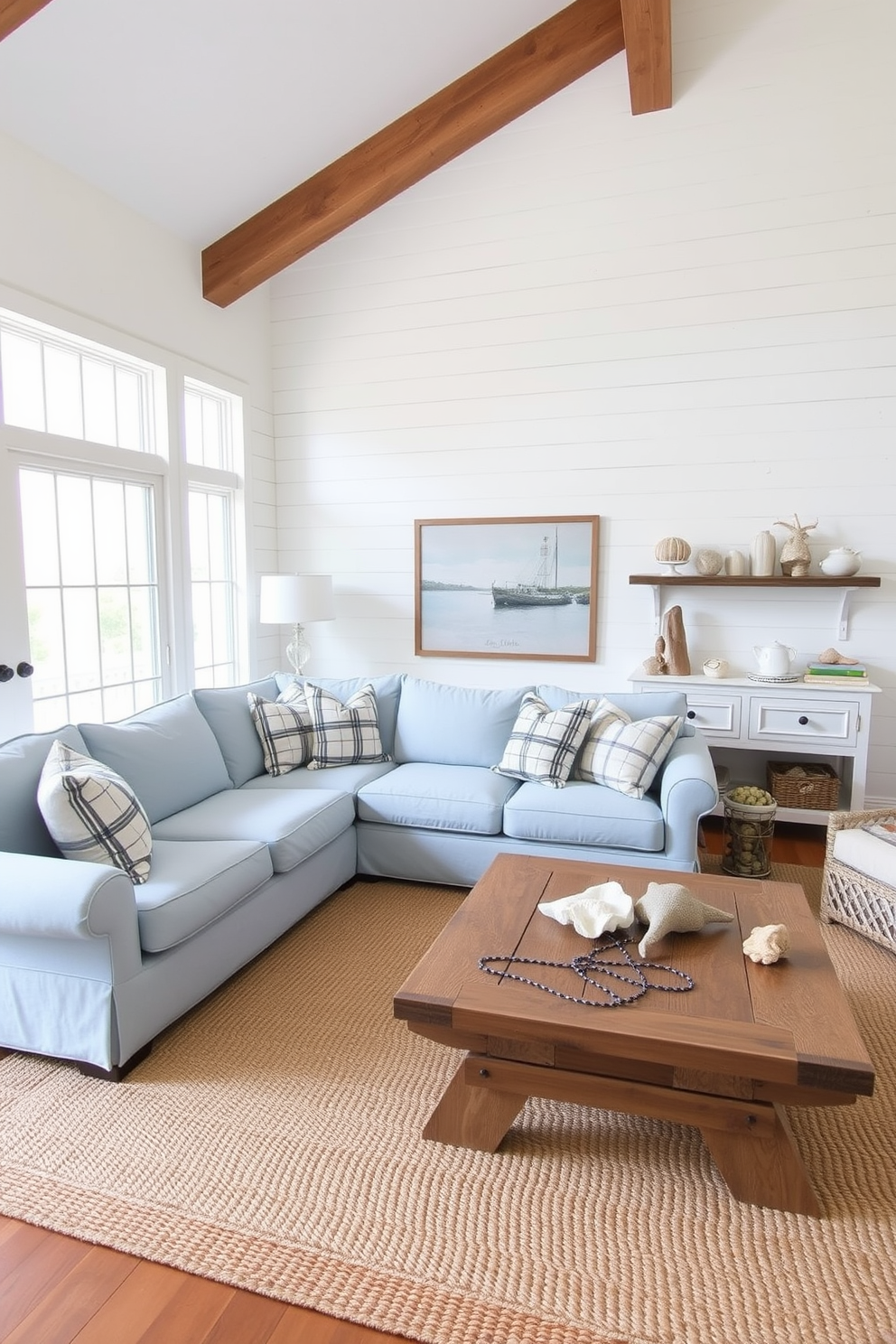 A bright coastal living room features an accent wall adorned with shiplap paneling painted in a soft white hue. The room is filled with natural light, showcasing a comfortable sectional sofa in light blue fabric paired with nautical-themed throw pillows. A large woven area rug anchors the seating area, while a rustic coffee table made of reclaimed wood adds warmth. Coastal decor elements like seashells and driftwood accents are artfully arranged on shelves and tabletops, enhancing the beachy vibe.