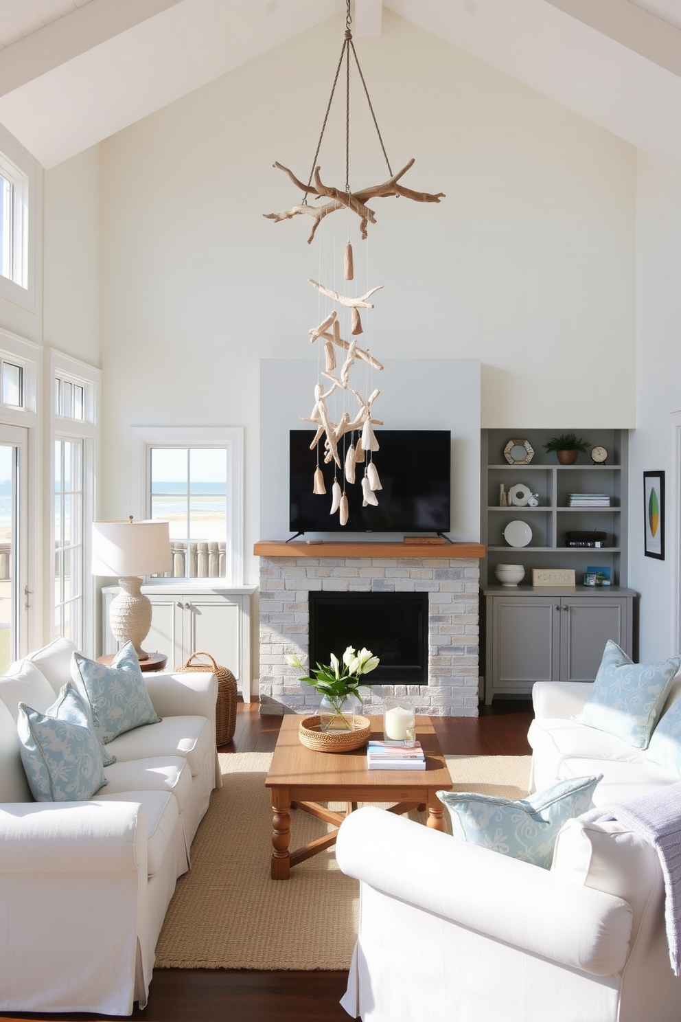 A coastal living room featuring a hanging driftwood mobile as the focal art piece. The space is bright and airy with light-colored furniture, soft blue accents, and large windows that invite natural light.