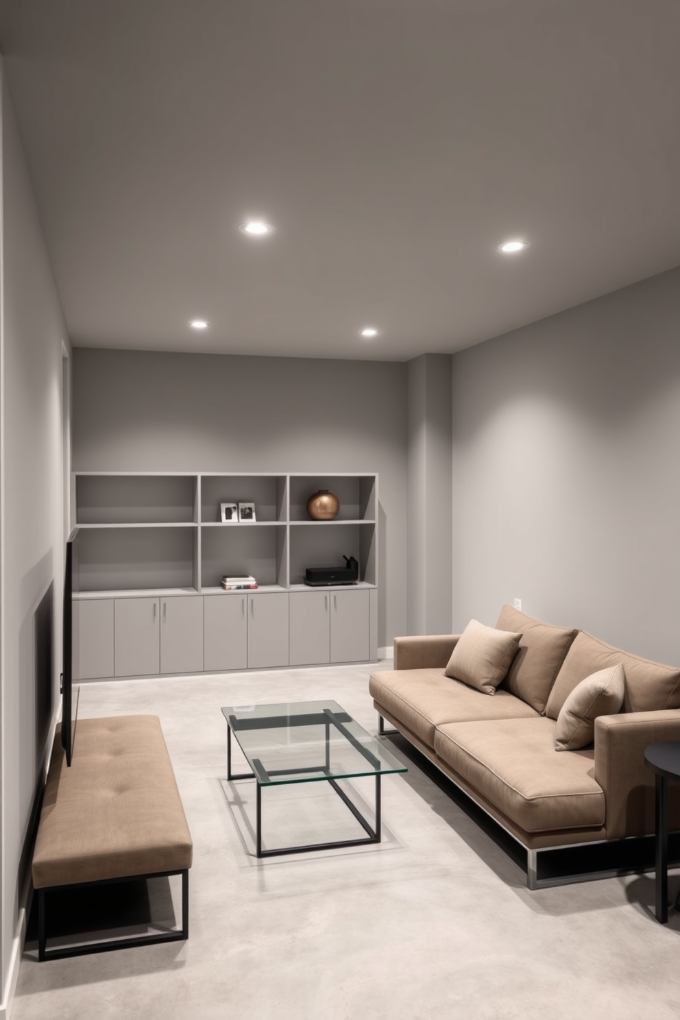 A minimalist basement design featuring sleek furniture choices. The walls are painted in a soft gray, and the floor is polished concrete with a matte finish. A low-profile sectional sofa in a neutral tone is positioned against one wall, complemented by a simple glass coffee table. Minimalist shelving units with clean lines display a few curated decor items, enhancing the uncluttered aesthetic.