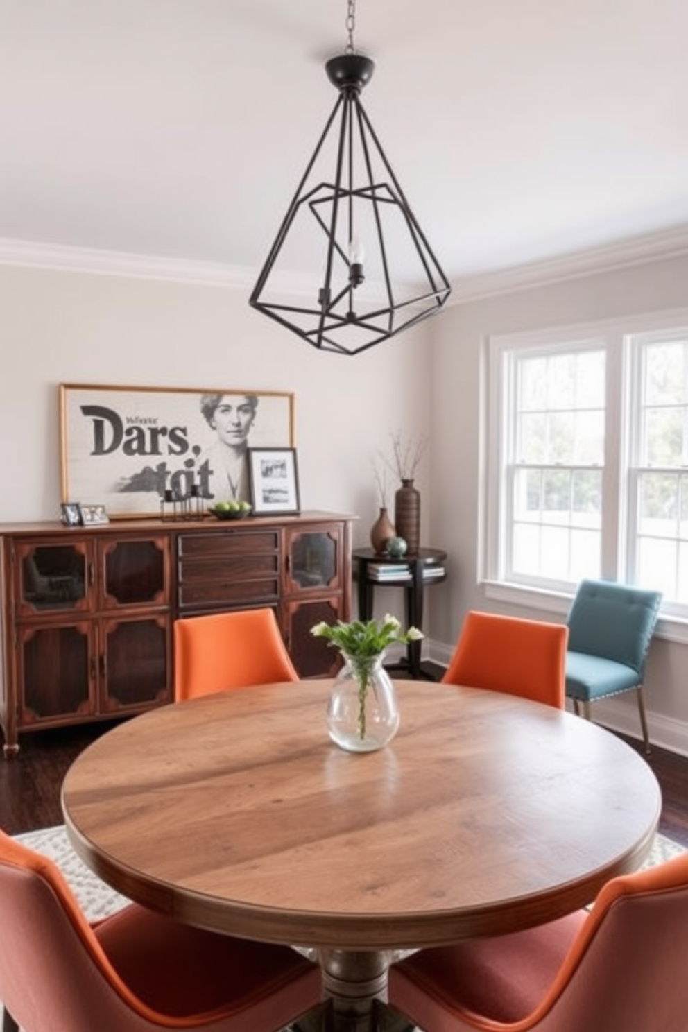 A contemporary dining room that harmoniously blends vintage and modern decor elements. A round wooden table with a distressed finish is surrounded by sleek, upholstered chairs in a bold color. Above the table, a striking modern chandelier with geometric shapes contrasts with a vintage sideboard against the wall. The room features a soft color palette, with large windows allowing natural light to illuminate the space and highlight the eclectic decor.