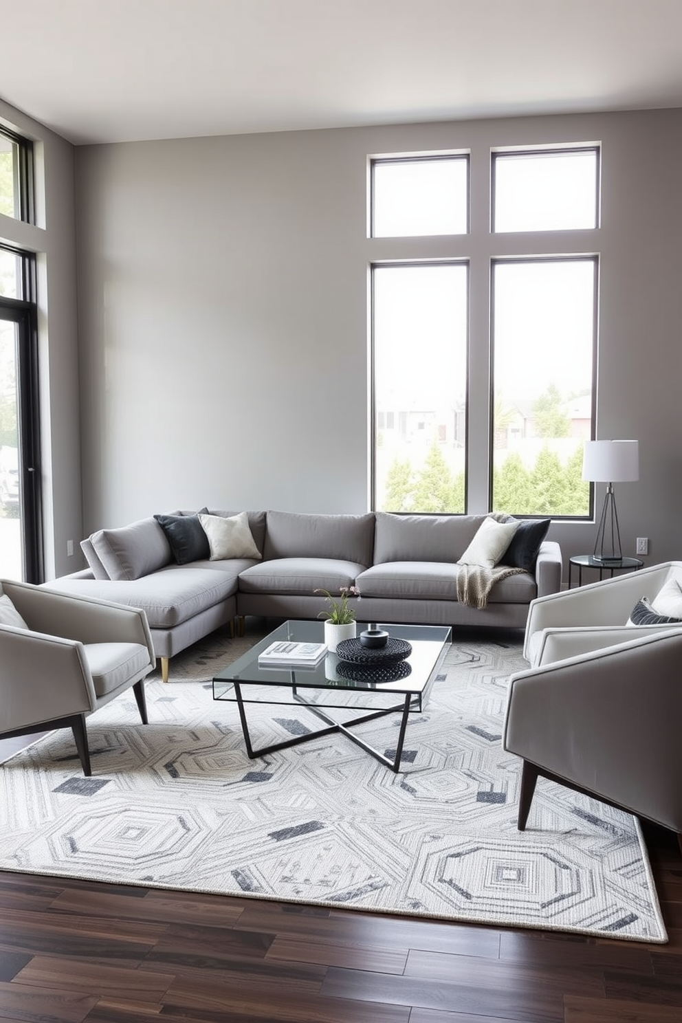 A contemporary family room featuring sleek furniture with geometric shapes. The space includes a low-profile sectional sofa with clean lines, a minimalist coffee table with a glass top, and accent chairs that showcase bold angles. The walls are painted in a soft gray hue, creating a calming backdrop. Large windows allow natural light to flood the room, highlighting a stylish area rug with a geometric pattern beneath the furniture.