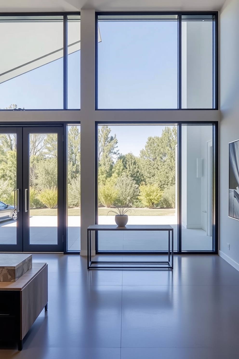 A contemporary foyer featuring expansive glass doors that invite natural light and create an open feel. The space is adorned with sleek furniture, including a minimalist console table and a statement art piece on the wall.