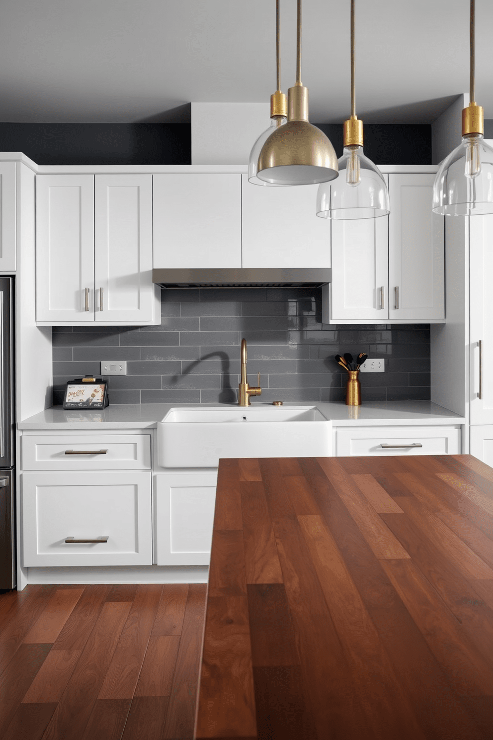 A contemporary kitchen featuring a blend of metal finishes. The cabinetry is sleek and minimalist with brushed nickel handles and a warm brass faucet above a large farmhouse sink. The countertop is a polished white quartz, complemented by a matte black backsplash. Pendant lights with mixed metal finishes hang above an island topped with a rich wooden surface, creating a striking focal point.