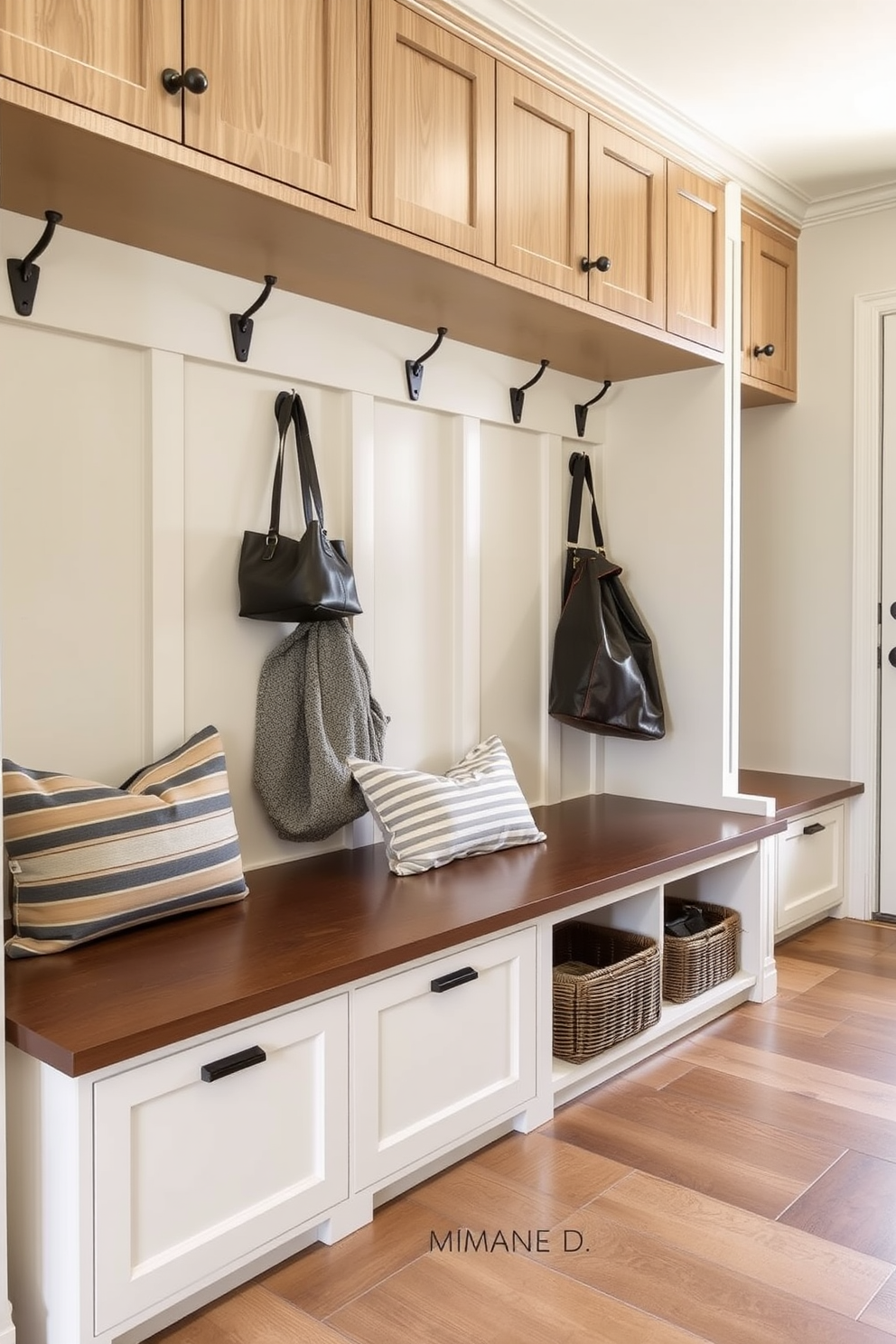 A contemporary mudroom features benches with hidden storage compartments underneath. The space is organized with built-in cabinetry, and the walls are adorned with stylish hooks for coats and bags.