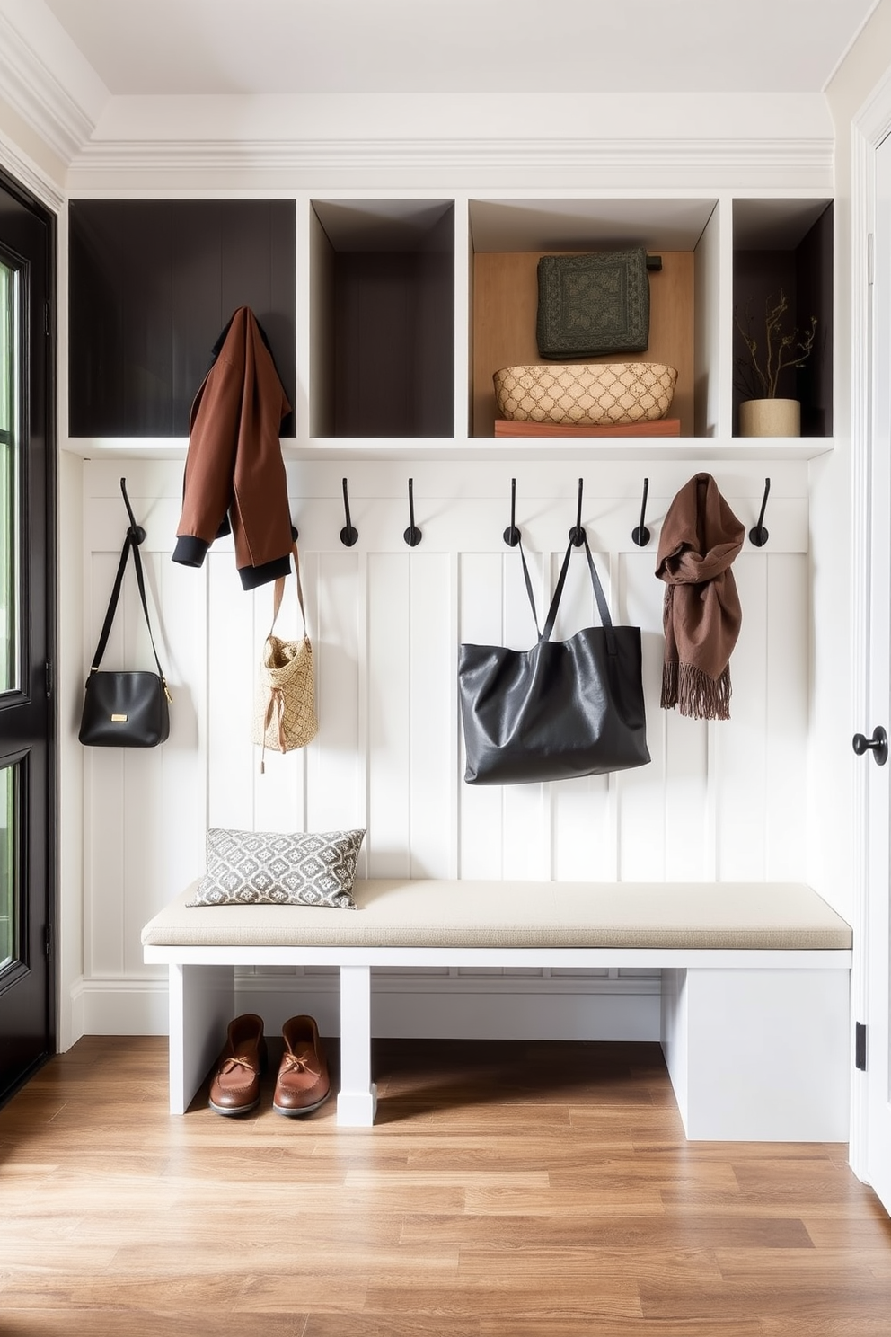 A contemporary mudroom features sleek wall hooks arranged in an organized manner for easy access to outerwear. The space is designed with a neutral color palette, complemented by a stylish bench and durable flooring that withstands heavy foot traffic.