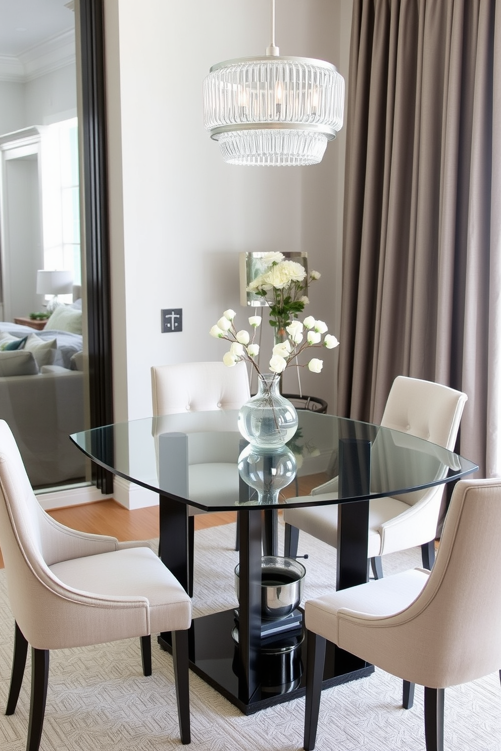 A corner dining room features a sleek glass table that enhances the airy ambiance of the space. Surrounding the table are elegant chairs with light fabric upholstery, creating a harmonious and inviting atmosphere.