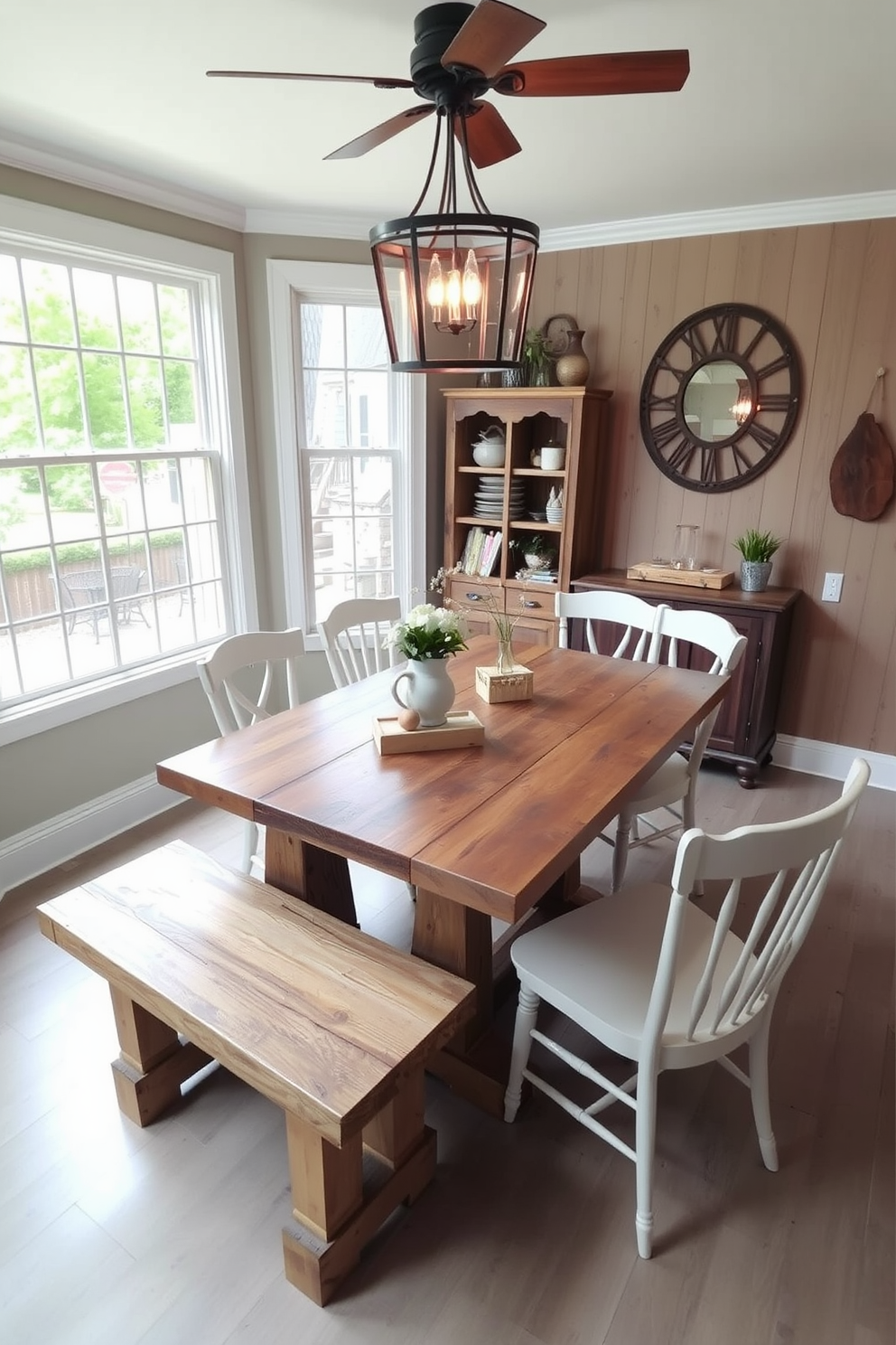 A charming corner dining room features a farmhouse table made of reclaimed wood, surrounded by a rustic bench on one side and mismatched chairs on the other. Large windows allow natural light to flood the space, highlighting the warm tones of the wood and the soft, neutral color palette of the decor.