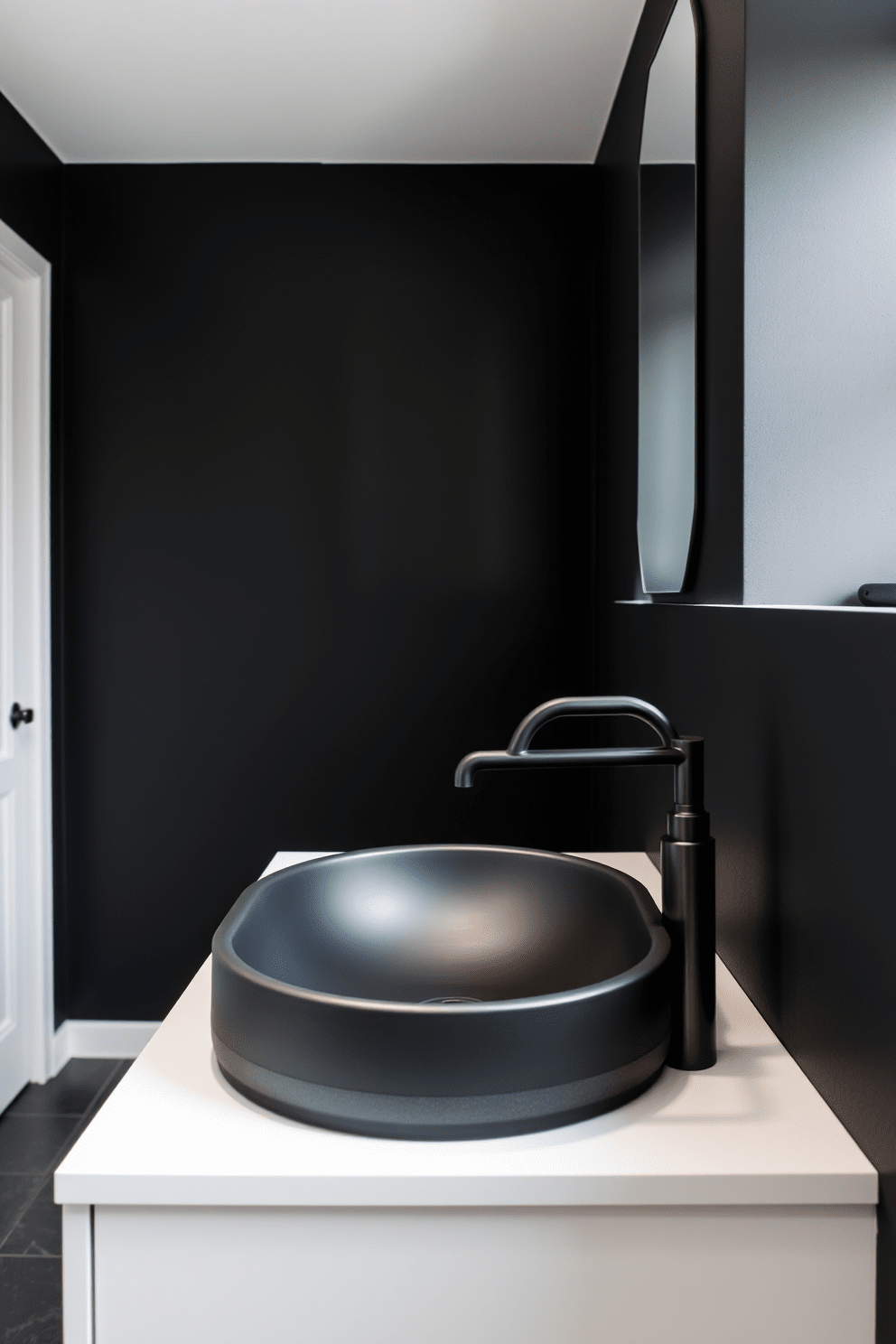 A striking dark bathroom featuring a matte black sink paired with a bold, modern faucet. The walls are painted in deep charcoal, creating a dramatic backdrop for sleek, minimalist fixtures.