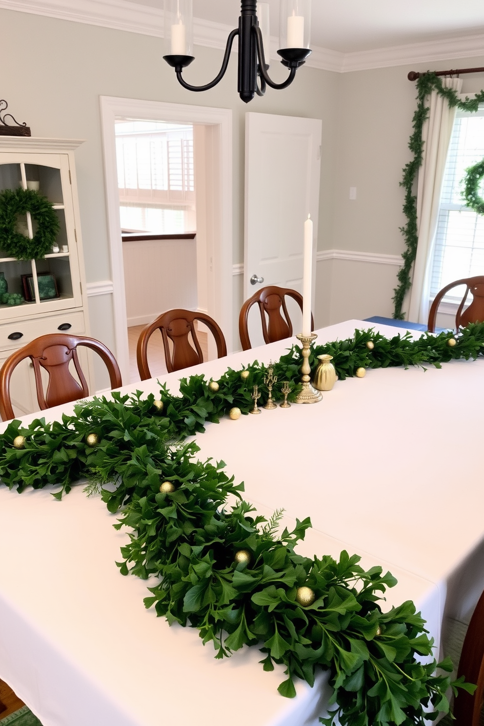 A dining room adorned for St. Patrick's Day features a long wooden table dressed with a crisp white tablecloth. Lush greenery garlands drape elegantly along the table, interspersed with small gold and green decorative accents.