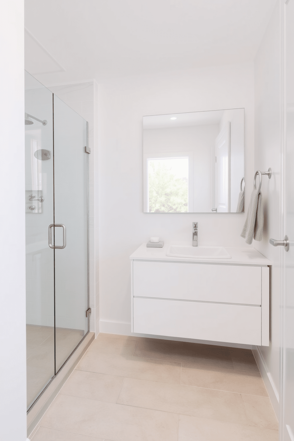 A bright and airy bathroom design featuring soft white walls and light gray tiles. The space includes a sleek glass shower enclosure and a floating vanity with a white sink and brushed nickel fixtures. The floor is adorned with light beige tiles that are easy to clean and maintain. A large mirror above the vanity reflects natural light, enhancing the cleanliness and openness of the room.