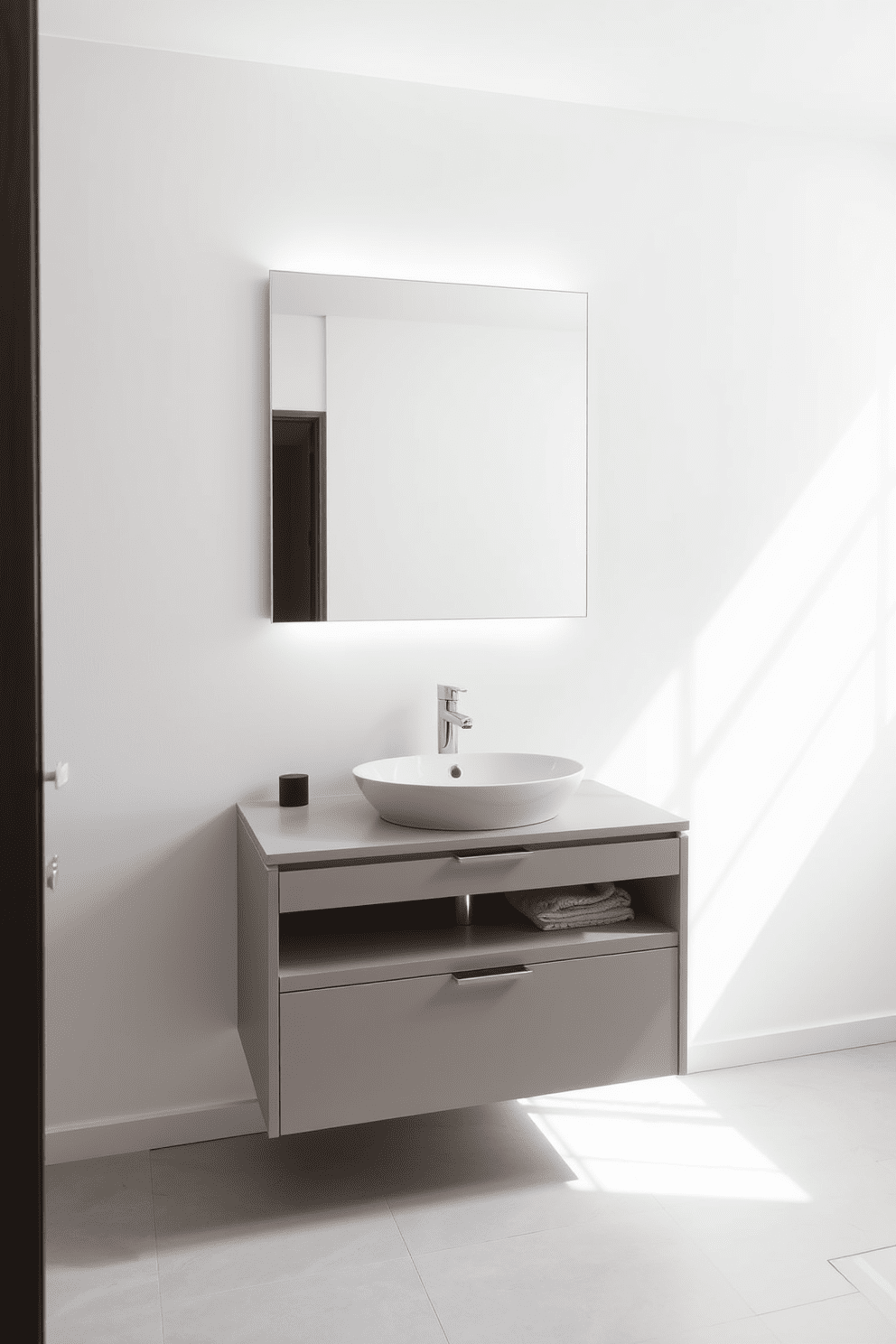 A minimalist bathroom design featuring a single basin sink with a sleek, modern faucet. The walls are painted in a soft white hue, complemented by light gray tiles on the floor for a clean and airy feel. Incorporate a floating vanity with ample storage space to keep the area tidy. A large frameless mirror above the sink enhances the sense of openness and reflects natural light.