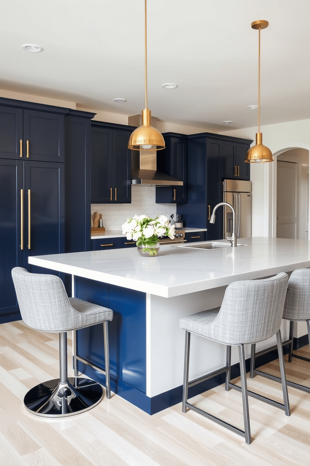 A stylish kitchen island features a sleek quartz countertop with a waterfall edge. Surrounding the island, there are modern bar stools upholstered in soft gray fabric for comfortable seating options. The cabinetry is a mix of navy blue and crisp white, creating a bold yet inviting contrast. Pendant lights with a brushed brass finish hang above the island, adding a touch of elegance to the space.