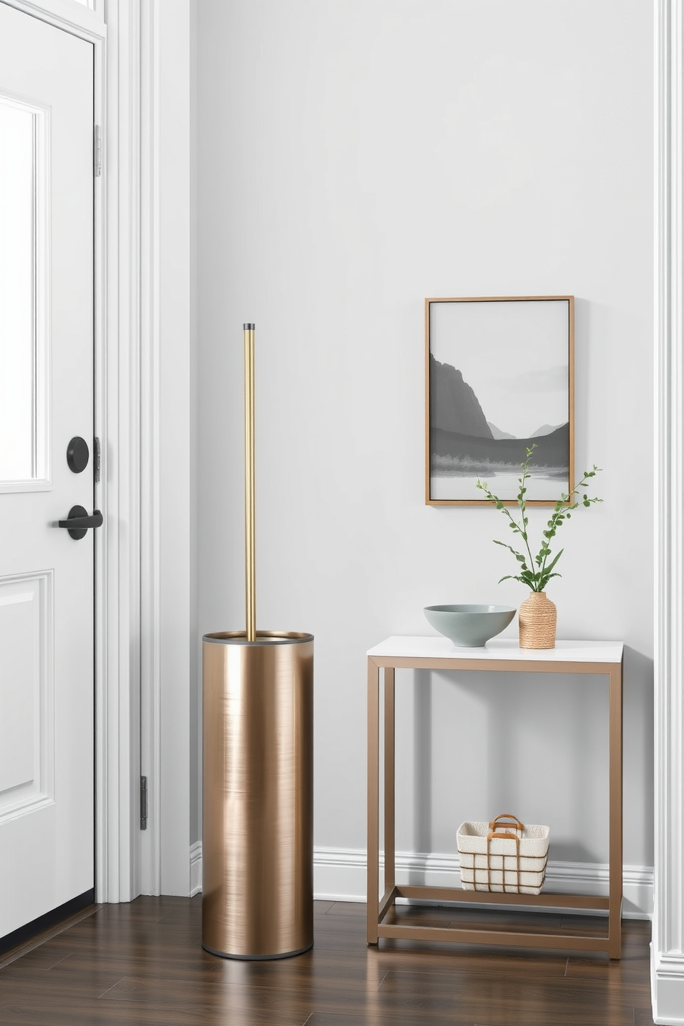 A stylish umbrella stand made of brushed metal is positioned near the door, complementing the modern aesthetic of the entrance foyer. The stand features a sleek design with a matte finish, providing a functional yet elegant touch to the space. The walls of the foyer are painted in a soft gray hue, enhancing the light and airy feel of the area. A small console table with a minimalist design sits beside the umbrella stand, adorned with a decorative bowl and a small potted plant for added charm.