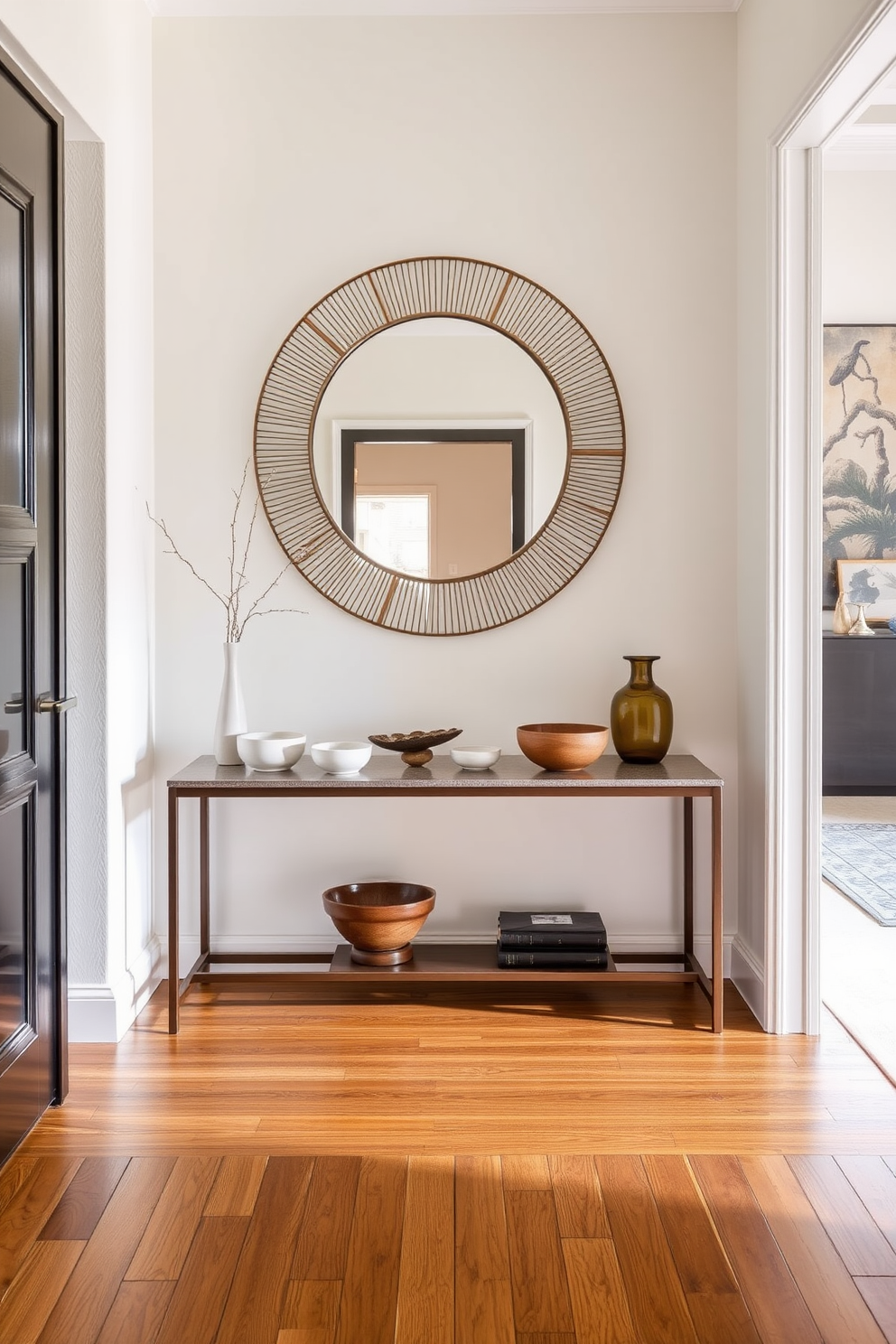 A stylish entrance foyer featuring a sleek console table against the wall. On the table, there are decorative bowls made of ceramic and wood, elegantly arranged to hold keys and small items. The walls are painted in a soft neutral tone, creating a warm and inviting atmosphere. A statement mirror hangs above the console table, reflecting light and enhancing the sense of space.