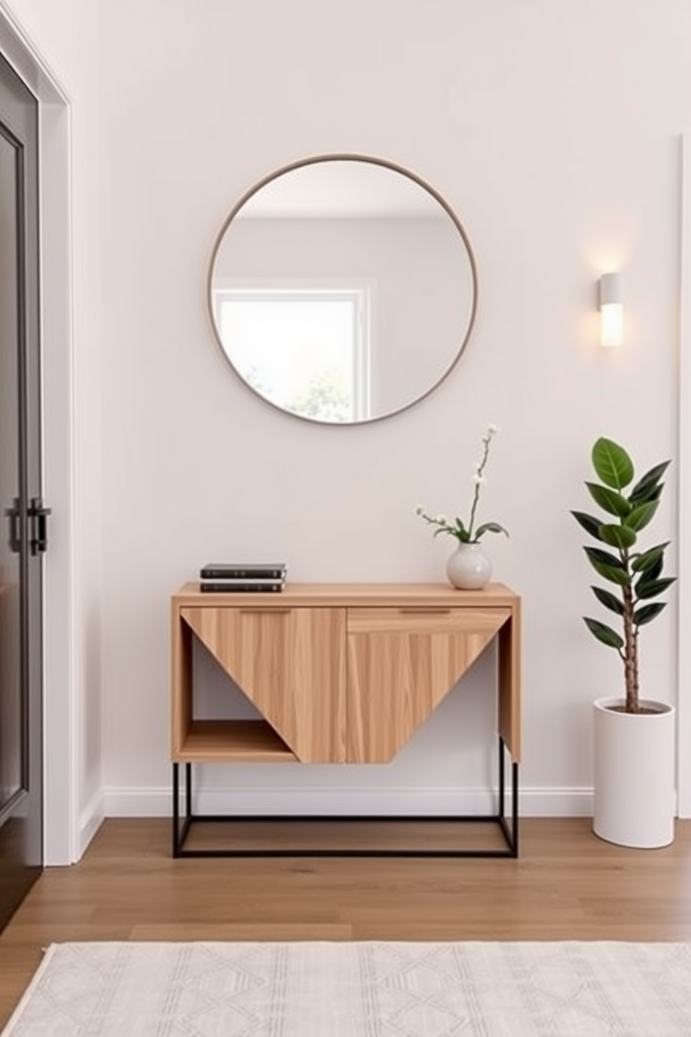 A minimalist entrance foyer features a sleek console table made of light wood with a simple geometric design. The walls are painted in a soft white, and a large round mirror hangs above the table, reflecting natural light from a nearby window. To the right, a small potted plant adds a touch of greenery, while a pair of minimalist wall sconces provide warm illumination. The floor is adorned with a light gray area rug that complements the overall clean aesthetic.