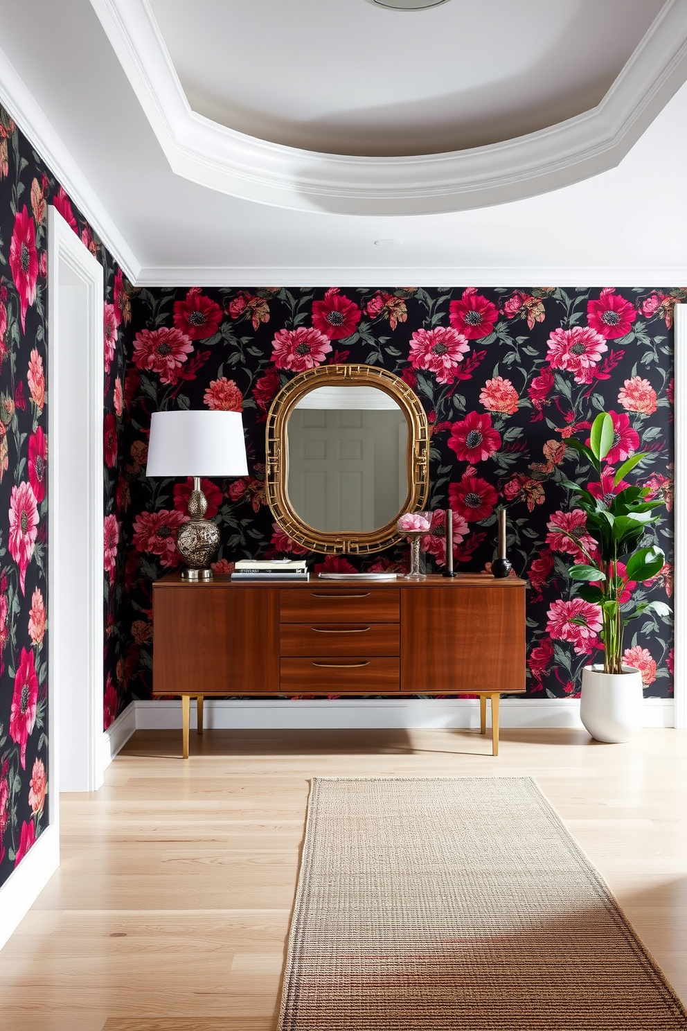 A stunning entryway featuring bold floral wallpaper that creates a vibrant backdrop. A sleek console table in a rich wood finish is positioned against the wall, topped with a decorative mirror and a stylish lamp. The floor is adorned with a chic runner rug that adds warmth and texture. A potted plant in the corner brings a touch of nature, complementing the overall design aesthetic.