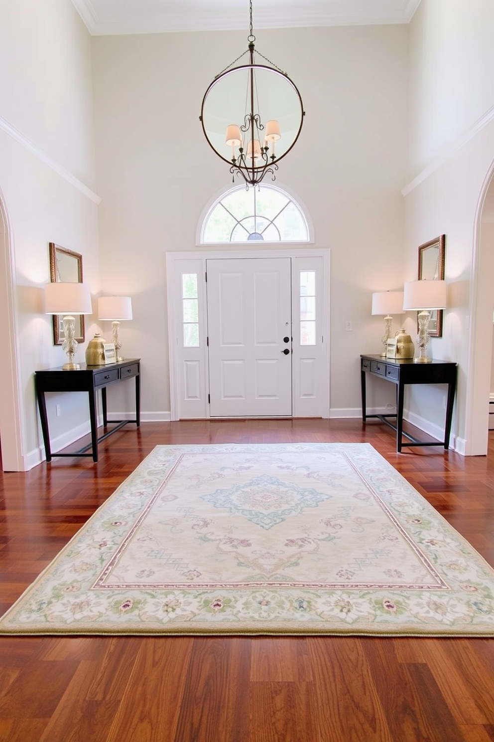 A spacious entryway featuring a large area rug that defines the space. The rug is in soft neutral tones and complements the hardwood flooring, creating a warm and inviting atmosphere. Flanking the entryway are two elegant console tables with decorative lamps. A large round mirror hangs above the tables, reflecting natural light and enhancing the sense of openness.