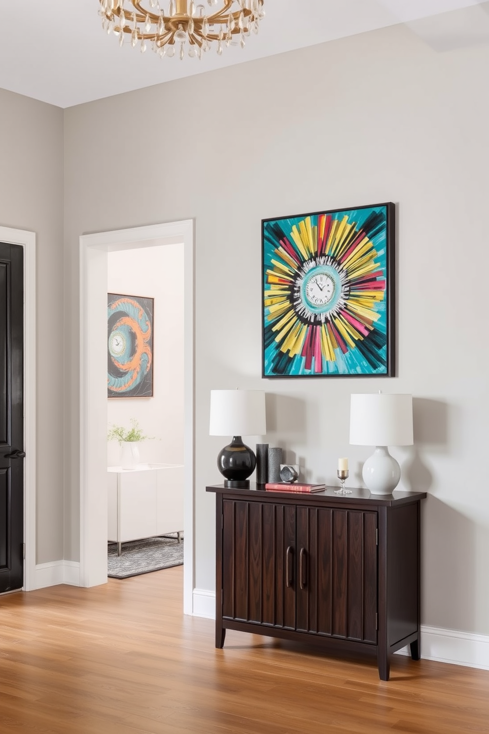 A stunning entryway design featuring a statement art piece that draws the eye. The walls are painted in a soft gray hue, providing a neutral backdrop for the vibrant artwork that hangs prominently. A sleek console table made of dark wood sits against the wall, adorned with decorative items and a stylish lamp. A large mirror with an ornate frame reflects the light, enhancing the sense of space and elegance in the entryway.