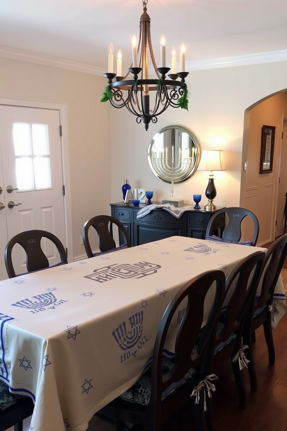 A festive tablecloth featuring a menorah motif drapes elegantly over a long dining table. Surrounding the table are chairs adorned with matching cushions, creating a warm and inviting atmosphere for holiday gatherings. The entryway is adorned with decorative elements that celebrate Hanukkah traditions. A beautiful menorah sits on a console table, complemented by blue and silver accents that enhance the festive spirit.