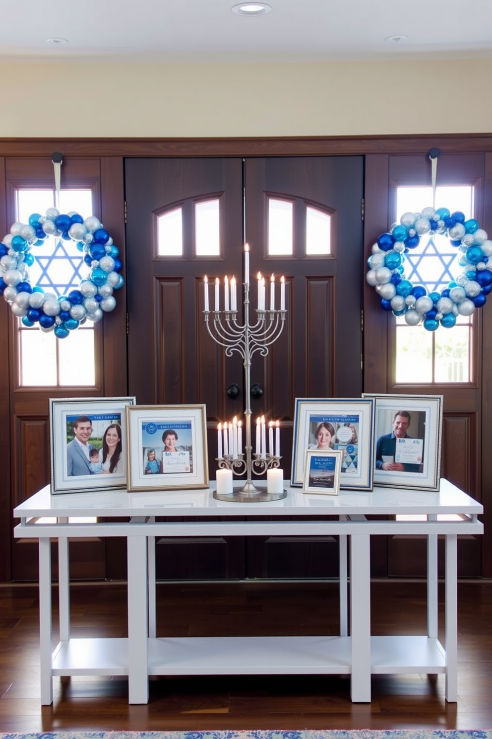 Framed family photos adorned with Hanukkah themes are displayed on a sleek console table. The entryway is warmly lit, creating an inviting atmosphere with blue and silver decorations reflecting the spirit of the holiday. A beautifully designed menorah sits prominently on the table, surrounded by festive candles. Wreaths made of blue and white ornaments hang on the doors, enhancing the celebratory feel of the space.