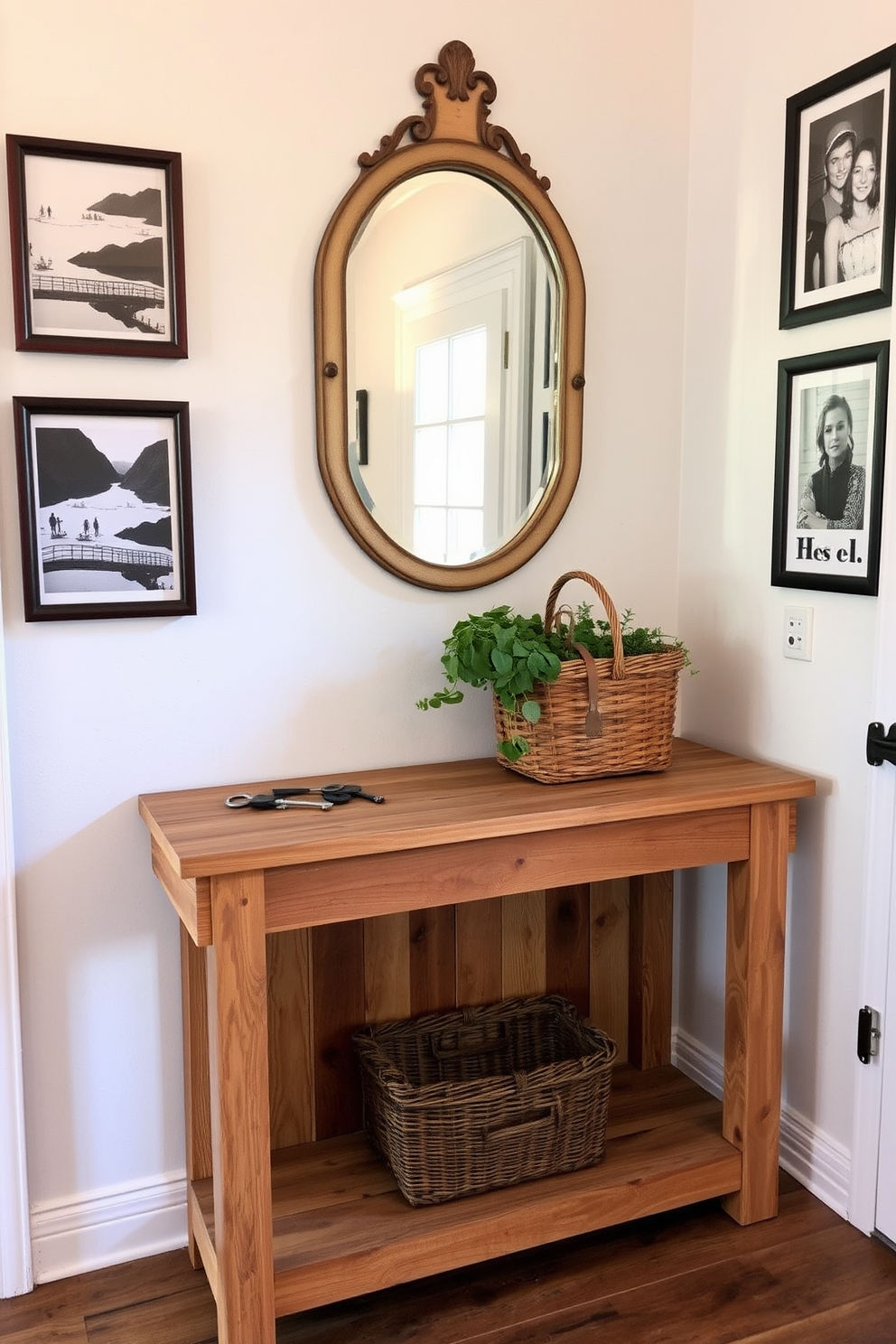 A rustic entryway features a reclaimed wood table with a natural finish. Above the table, a vintage mirror reflects the warm light from a nearby window, enhancing the inviting atmosphere. On the table, a woven basket holds fresh greenery, while a set of antique keys adds a touch of character. The walls are adorned with framed black and white photographs, creating a cozy and personal entryway space.