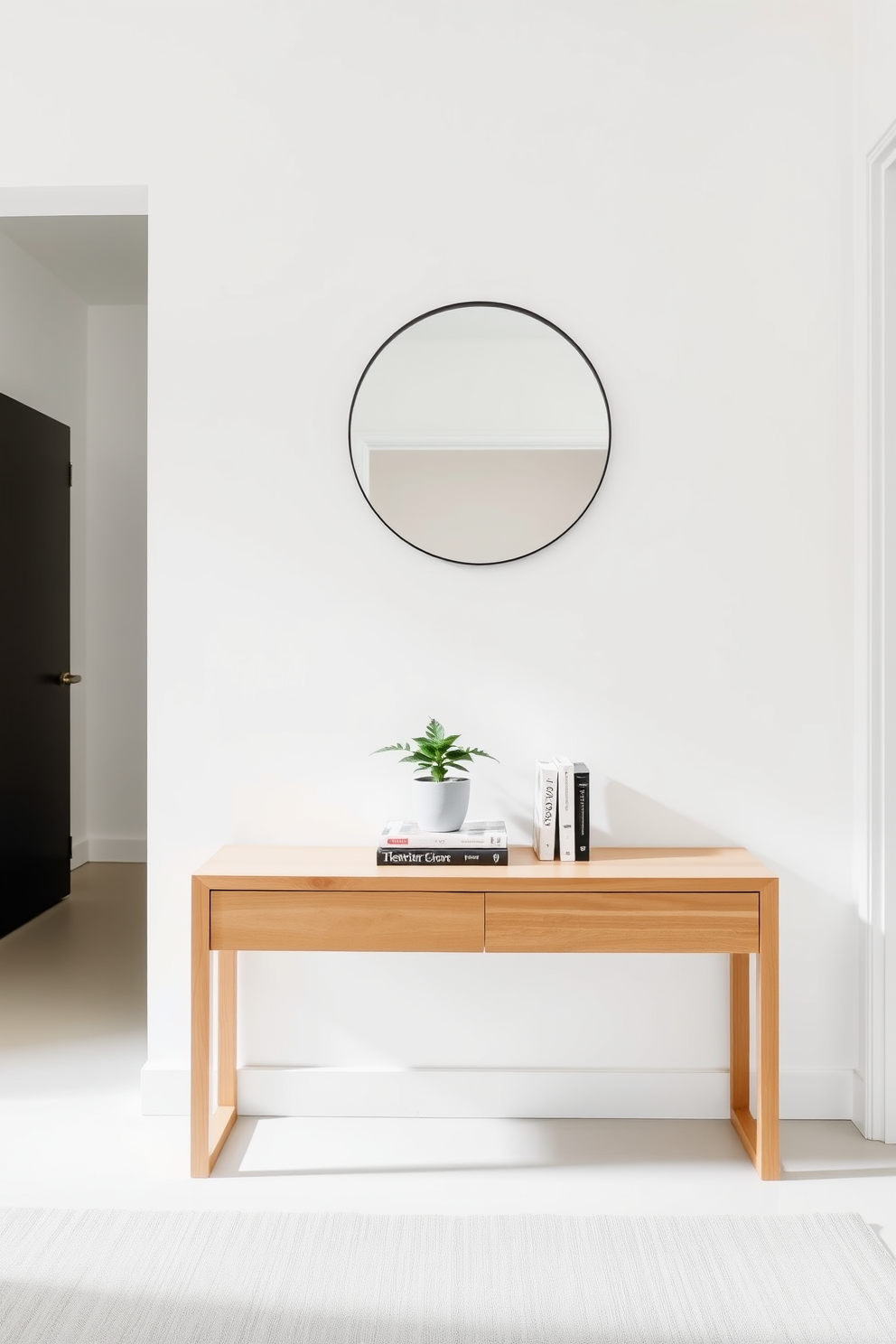 A minimalist entryway featuring a sleek wooden table with clean lines and a light finish. Above the table, a simple round mirror reflects natural light, enhancing the airy feel of the space. On the table, a small potted plant adds a touch of greenery, while a few carefully selected books create a subtle focal point. The walls are painted in a soft white, and the floor is adorned with a light gray rug to add warmth without clutter.