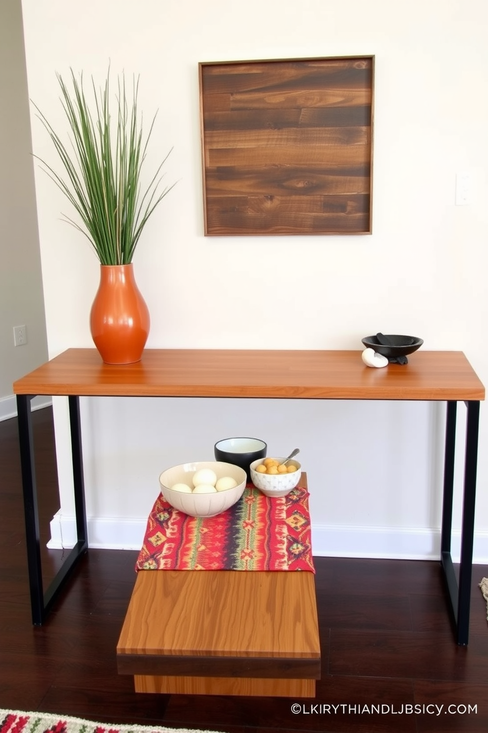 A stylish entryway table is adorned with decorative bowls for keys and small items. The table features a sleek wooden surface with a warm finish, complemented by a vibrant runner that adds a pop of color. On the table, a set of ceramic bowls in varying sizes and textures creates an inviting focal point. The wall behind is painted in a soft neutral tone, enhancing the overall aesthetic of the space.