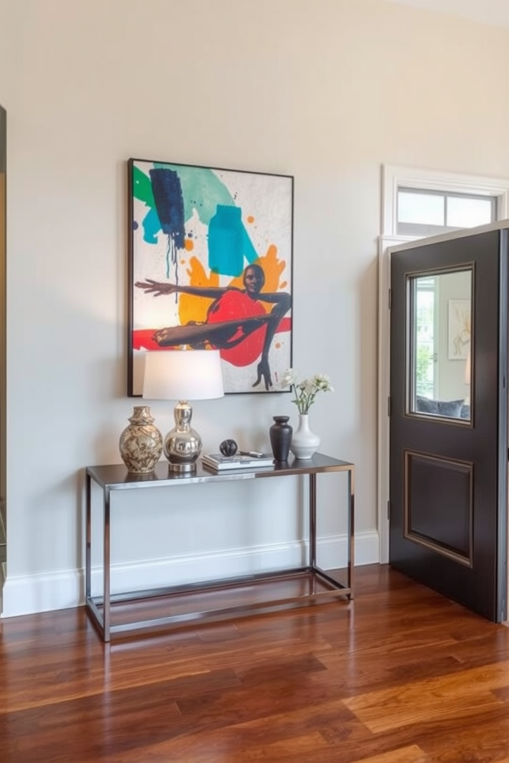 A striking entryway features a large abstract artwork that draws the eye immediately upon entering. The walls are painted in a soft neutral tone, creating a perfect backdrop for the vibrant colors of the artwork. To enhance the visual appeal, a sleek console table sits below the artwork, adorned with decorative objects and a stylish lamp. The floor is finished with elegant hardwood, complementing the overall design while adding warmth to the space.