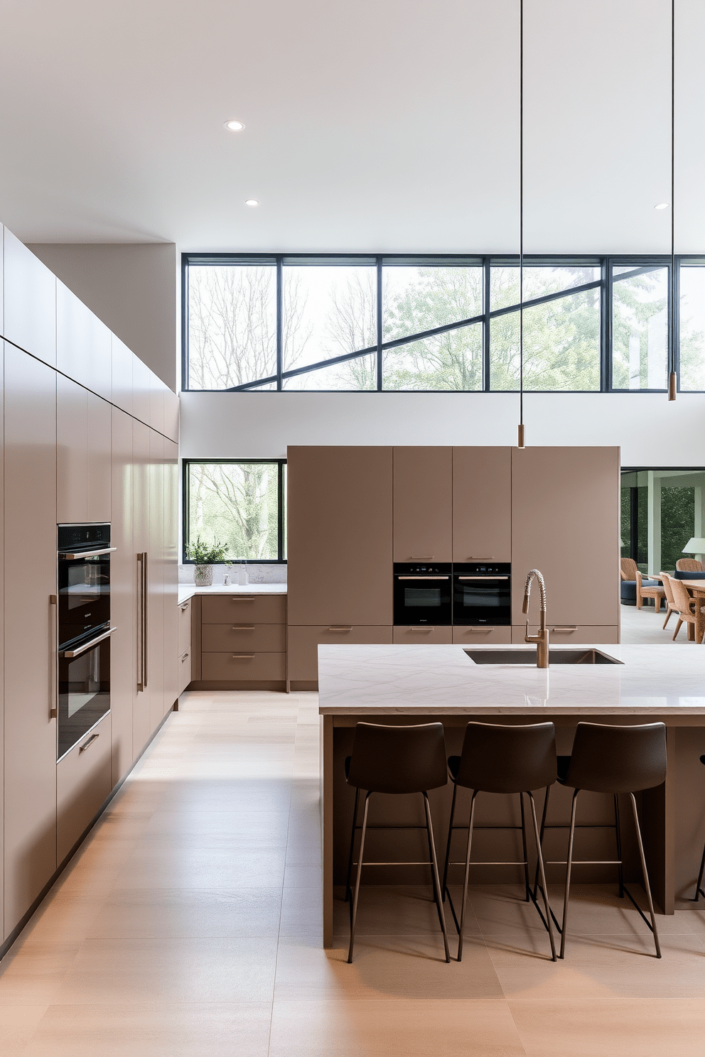 A modern European kitchen featuring integrated appliances that blend seamlessly into the cabinetry. The design showcases a spacious layout with a large island in the center, topped with a polished stone surface and surrounded by stylish bar stools. The cabinetry is a mix of matte and glossy finishes in neutral tones, creating a sophisticated atmosphere. Large windows provide ample natural light, highlighting the sleek lines and contemporary fixtures throughout the space.