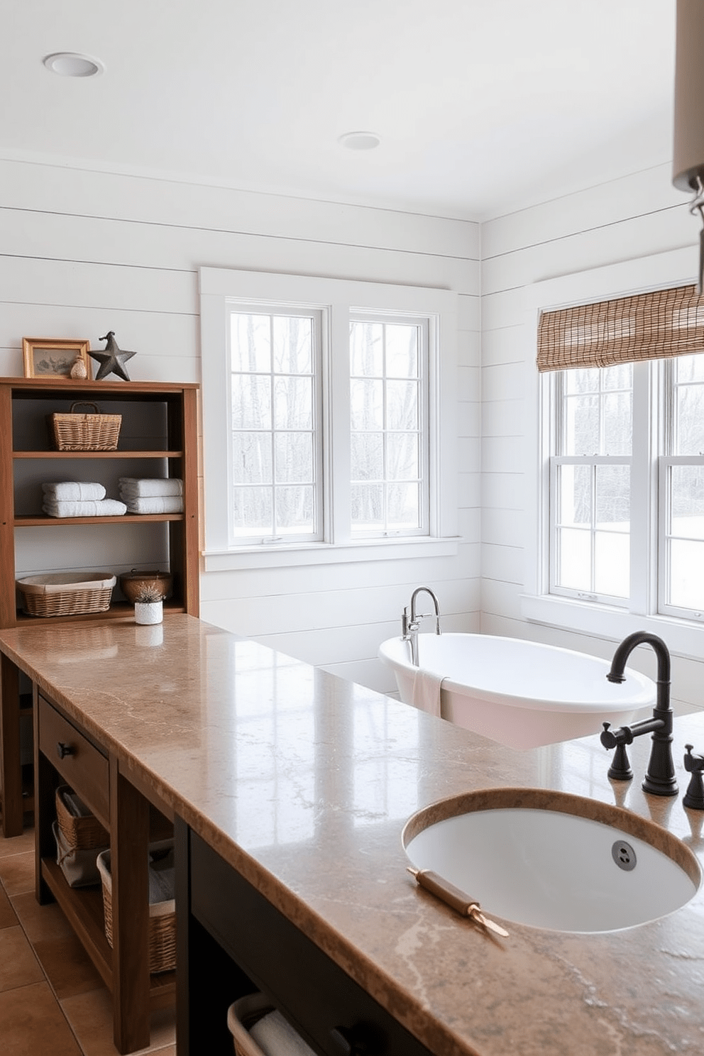 A charming farmhouse bathroom featuring natural stone countertops that emphasize durability and rustic elegance. The space includes a freestanding soaking tub with a vintage-style faucet, surrounded by shiplap walls painted in soft white. A wooden vanity with open shelving showcases neatly arranged towels and baskets, enhancing the farmhouse aesthetic. Large windows allow natural light to flood the room, highlighting the earthy tones of the decor and the textured stone surfaces.