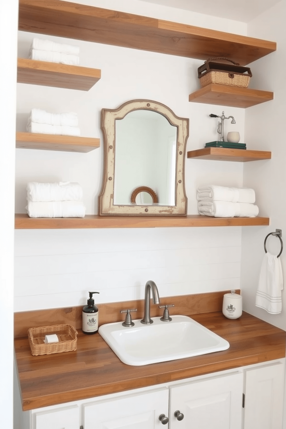 Open shelving creates a functional and stylish storage solution in a farmhouse bathroom. The shelves are made of reclaimed wood, displaying neatly folded towels and rustic decor items. The walls are painted in a soft white, complementing the natural wood tones. A vintage mirror hangs above a farmhouse sink, adding charm to the overall design.