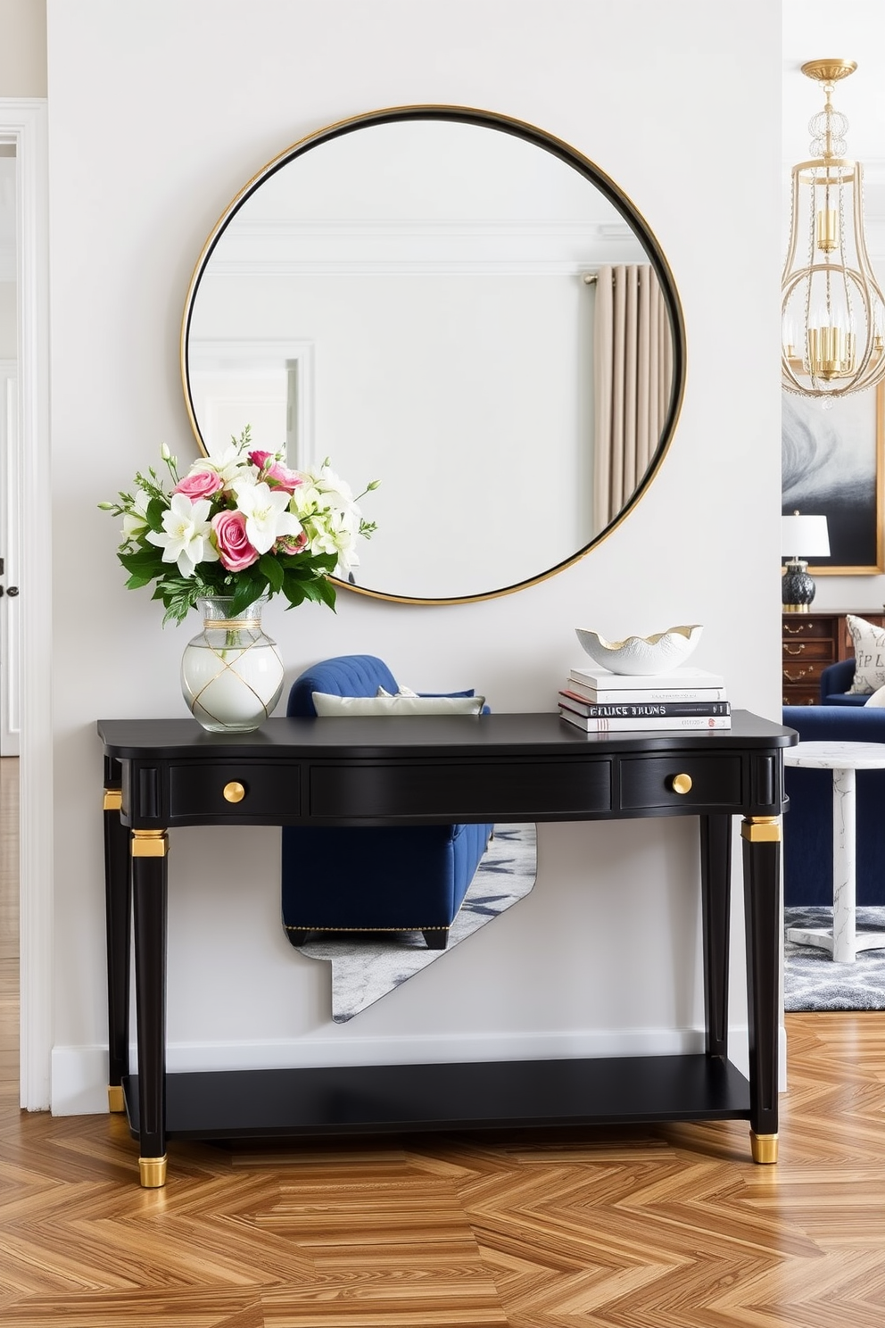 A stylish console table for the entryway is made of dark wood with elegant gold accents. It is adorned with a large round mirror above it, and decorative items such as a vase with fresh flowers and a stack of art books are placed on top. Formal living room design ideas feature a plush sectional sofa in a rich navy blue fabric. The room is accented with a pair of marble side tables and a statement chandelier that adds a touch of glamour to the space.