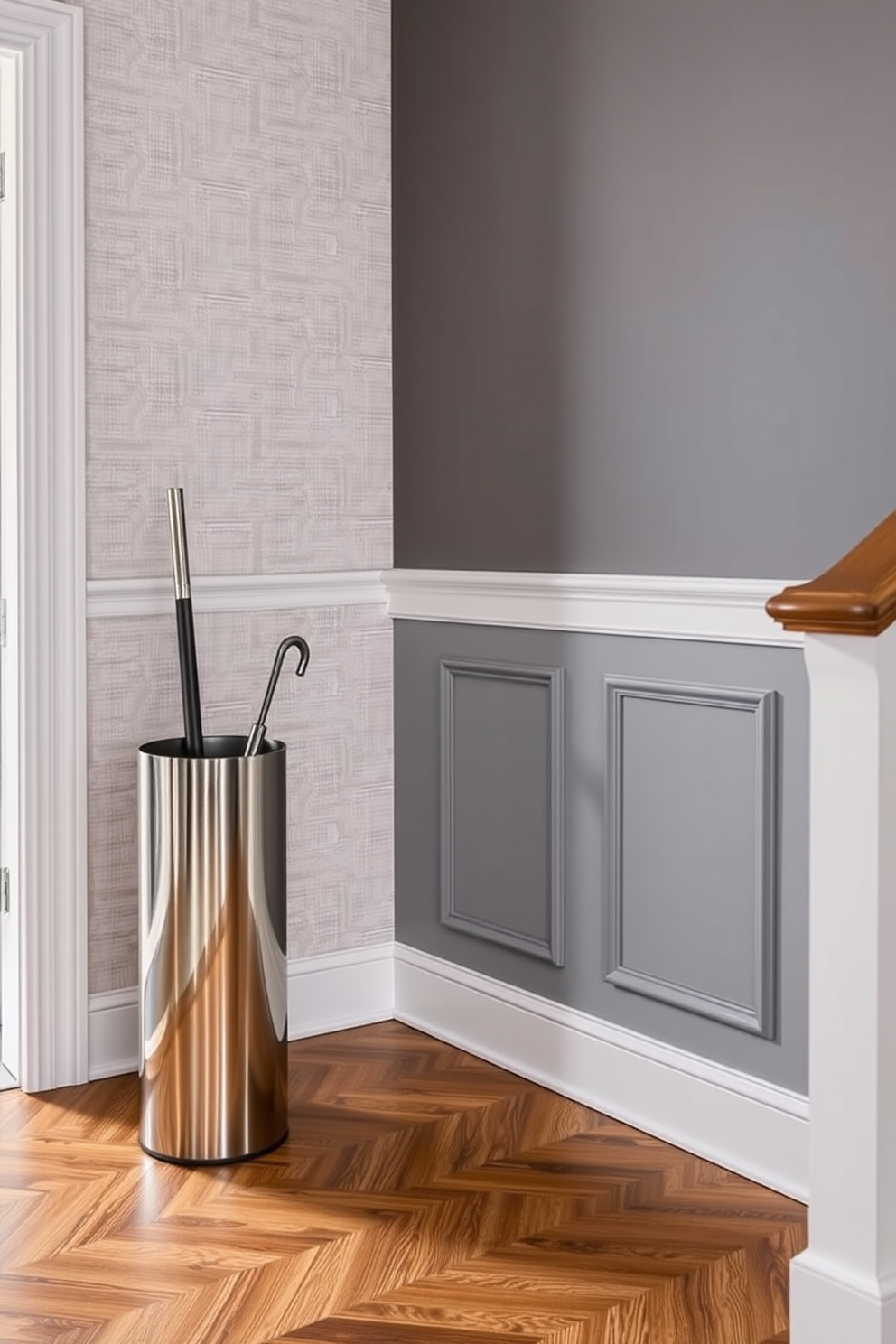 A stylish foyer featuring a sleek umbrella stand made of brushed stainless steel, positioned near the entrance. The walls are adorned with soft gray wallpaper, and the floor is covered with elegant herringbone-patterned hardwood.