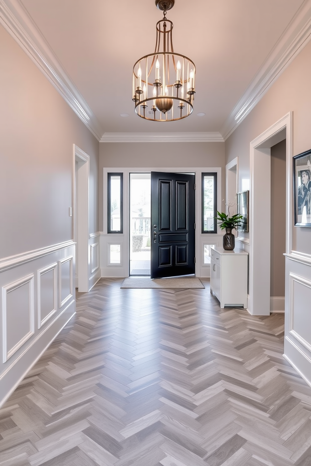 A stunning foyer features a herringbone pattern tile in soft gray and white, creating a sophisticated and elegant entryway. The walls are adorned with sleek wainscoting, and a statement chandelier hangs above, illuminating the space beautifully.