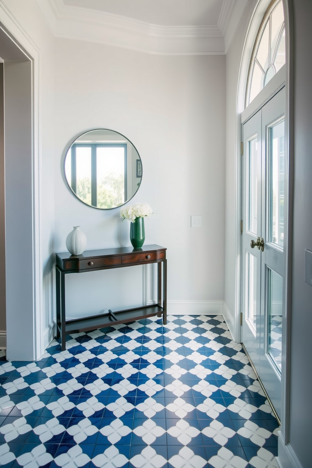 A stunning foyer featuring patterned tiles that create a captivating visual interest. The tiles are arranged in a geometric design, combining shades of blue and white, which enhances the entryway's elegance. Adjacent to the patterned tiles, a sleek console table made of dark wood stands against the wall. Above the table, a large round mirror reflects the natural light streaming in from a nearby window, adding depth to the space.