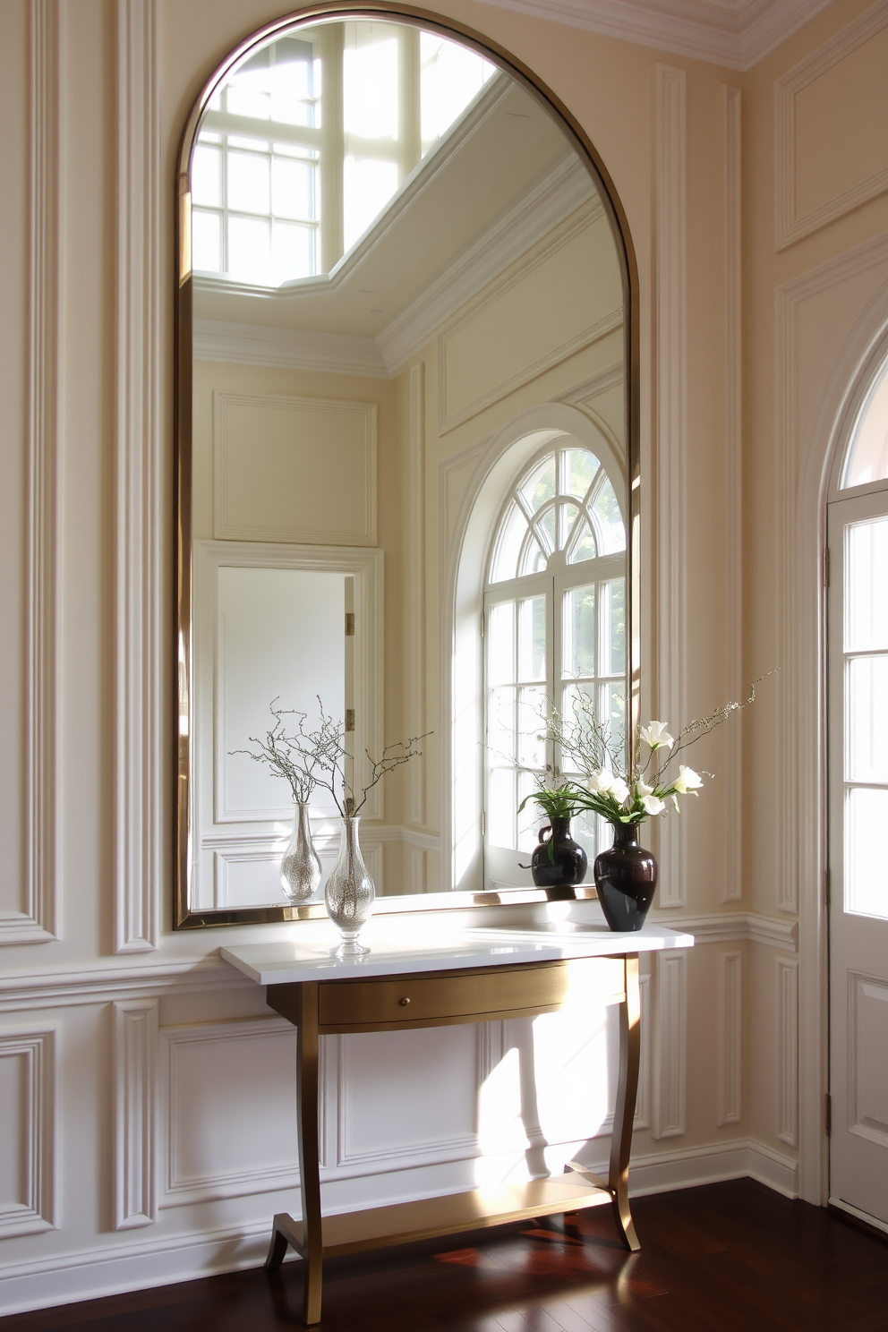 A stunning foyer featuring a large mirror that reflects light and enhances the sense of space. The walls are adorned with elegant paneling painted in a soft cream color, complemented by a stylish console table below the mirror.