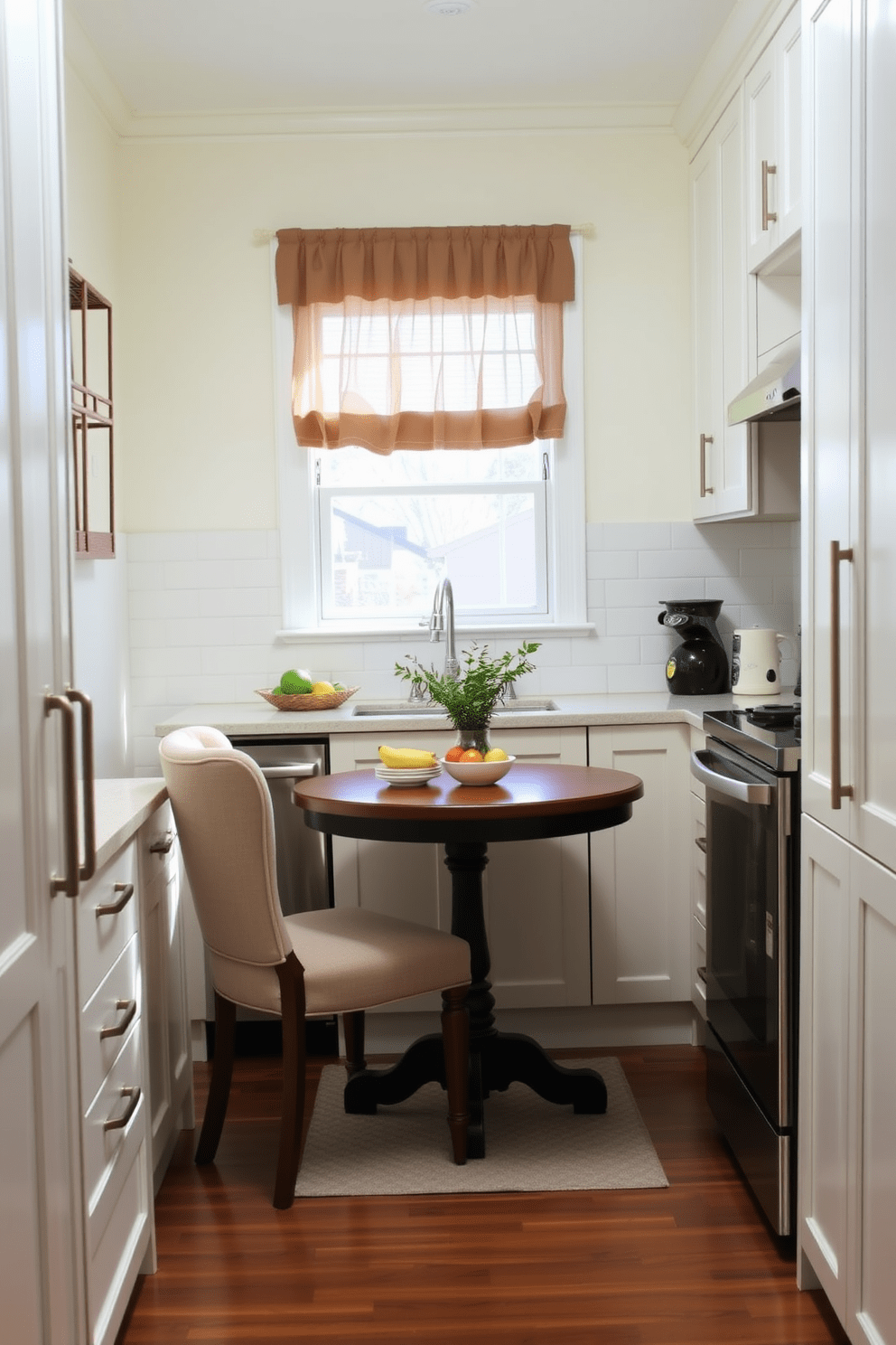 A cozy galley kitchen featuring a small breakfast nook with a round wooden table and two upholstered chairs. The kitchen cabinets are painted in a soft white, complemented by a subway tile backsplash and stainless steel appliances. Natural light floods the space through a window above the sink, adorned with sheer curtains. The breakfast nook is decorated with a small vase of fresh herbs and a colorful fruit bowl, adding warmth and charm to the design.