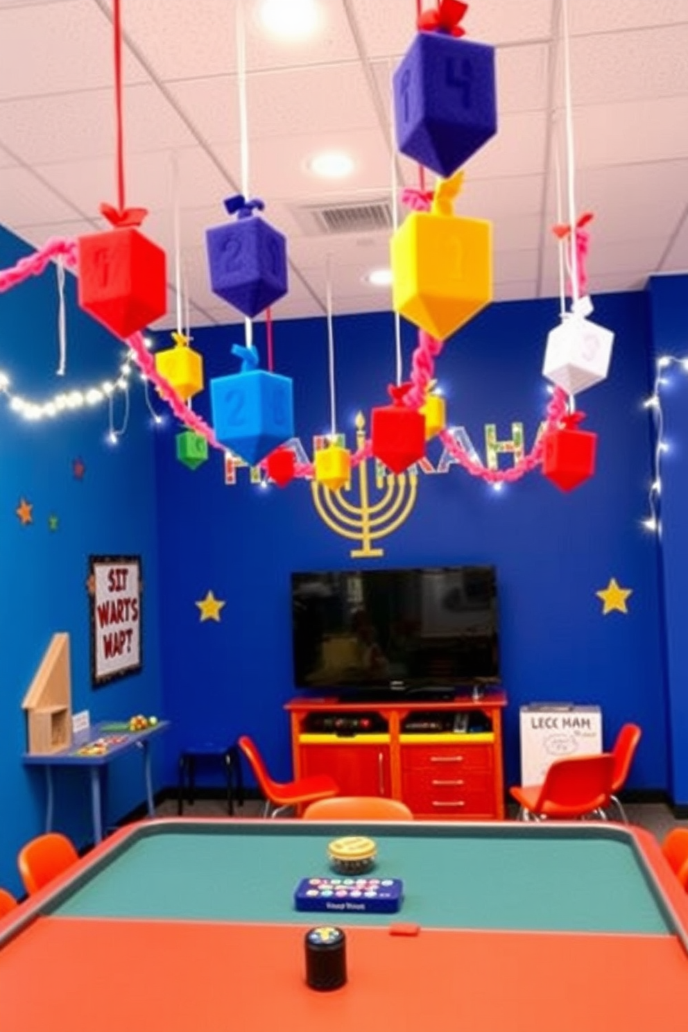 A vibrant game room decorated for Hanukkah features colorful felt dreidel garlands hanging from the ceiling. The walls are adorned with cheerful artwork and twinkling string lights, creating a festive atmosphere perfect for celebrations.