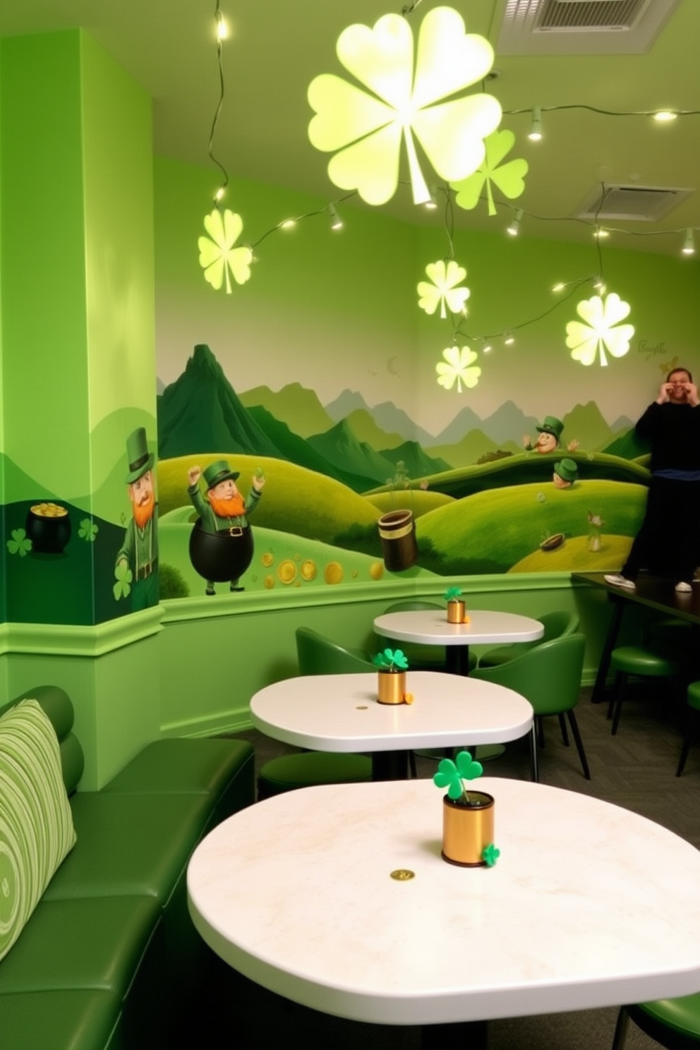 A vibrant game room featuring St. Patrick's Day themed wall murals that showcase lush green landscapes and playful leprechauns. The space is filled with comfortable seating and gaming tables adorned with festive decorations like shamrocks and gold coins. The walls are painted in a cheerful light green hue, creating a lively atmosphere. String lights in the shape of shamrocks hang from the ceiling, adding a whimsical touch to the overall design.