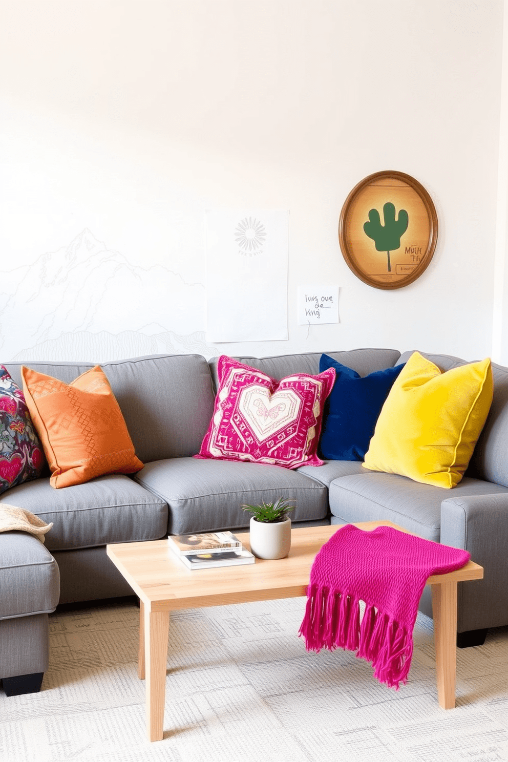 Cozy gray sectional sofa adorned with vibrant colorful pillows. The walls are painted in soft white, and the space features a light wood coffee table with a few stylish books and a decorative plant.